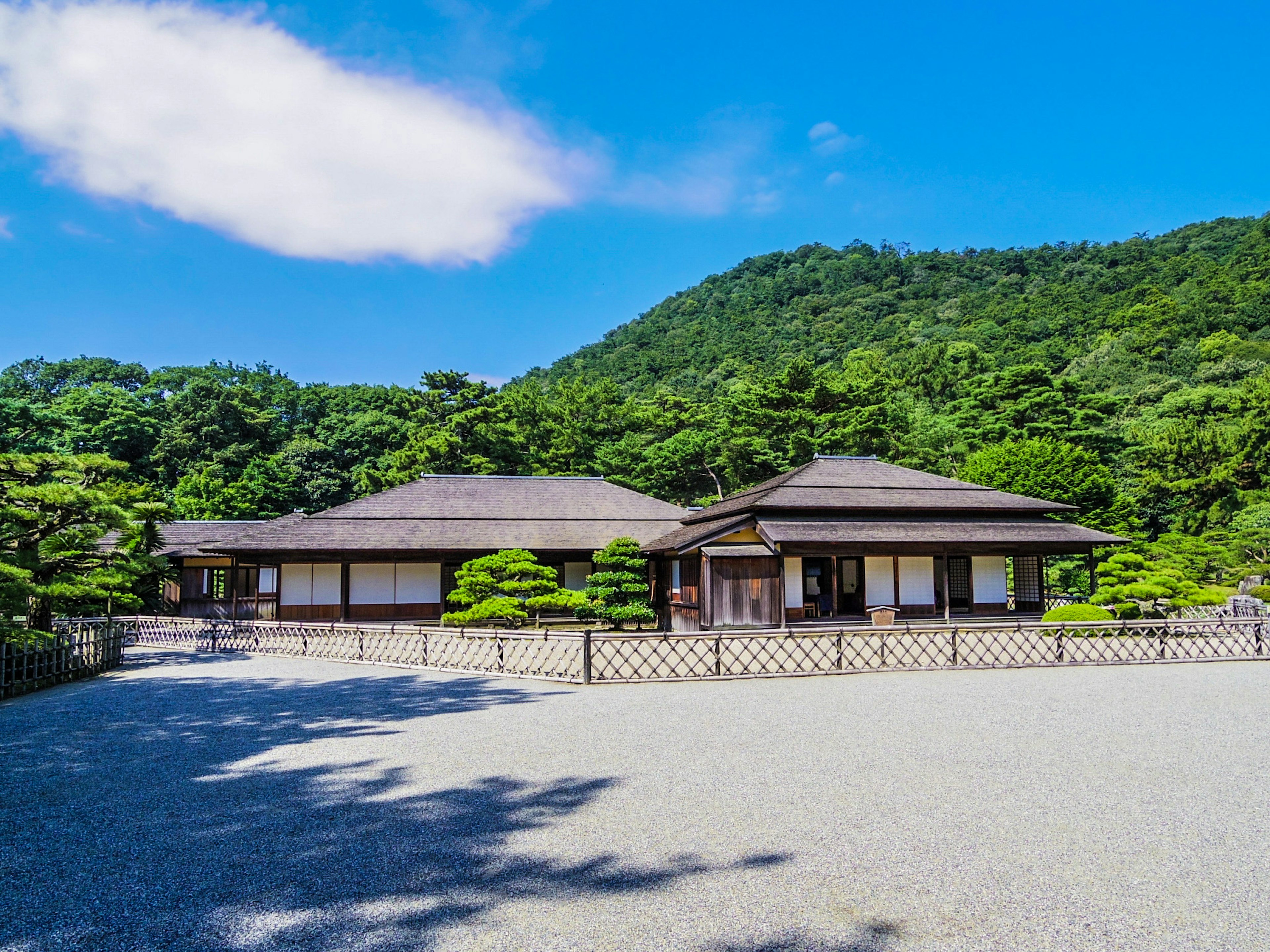 Traditional Japanese house surrounded by greenery and mountains