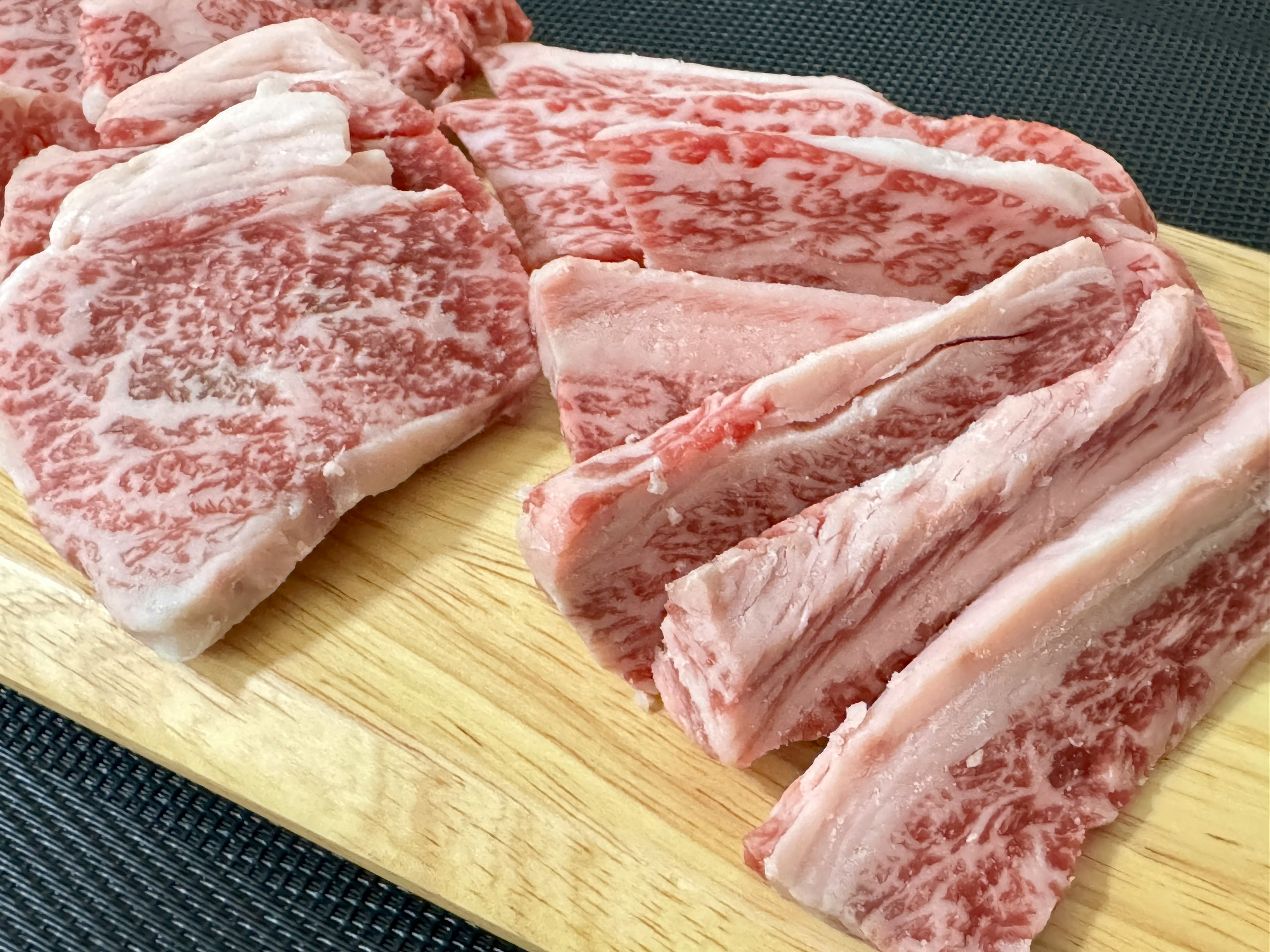 Beautiful slices of Wagyu beef arranged on a wooden board