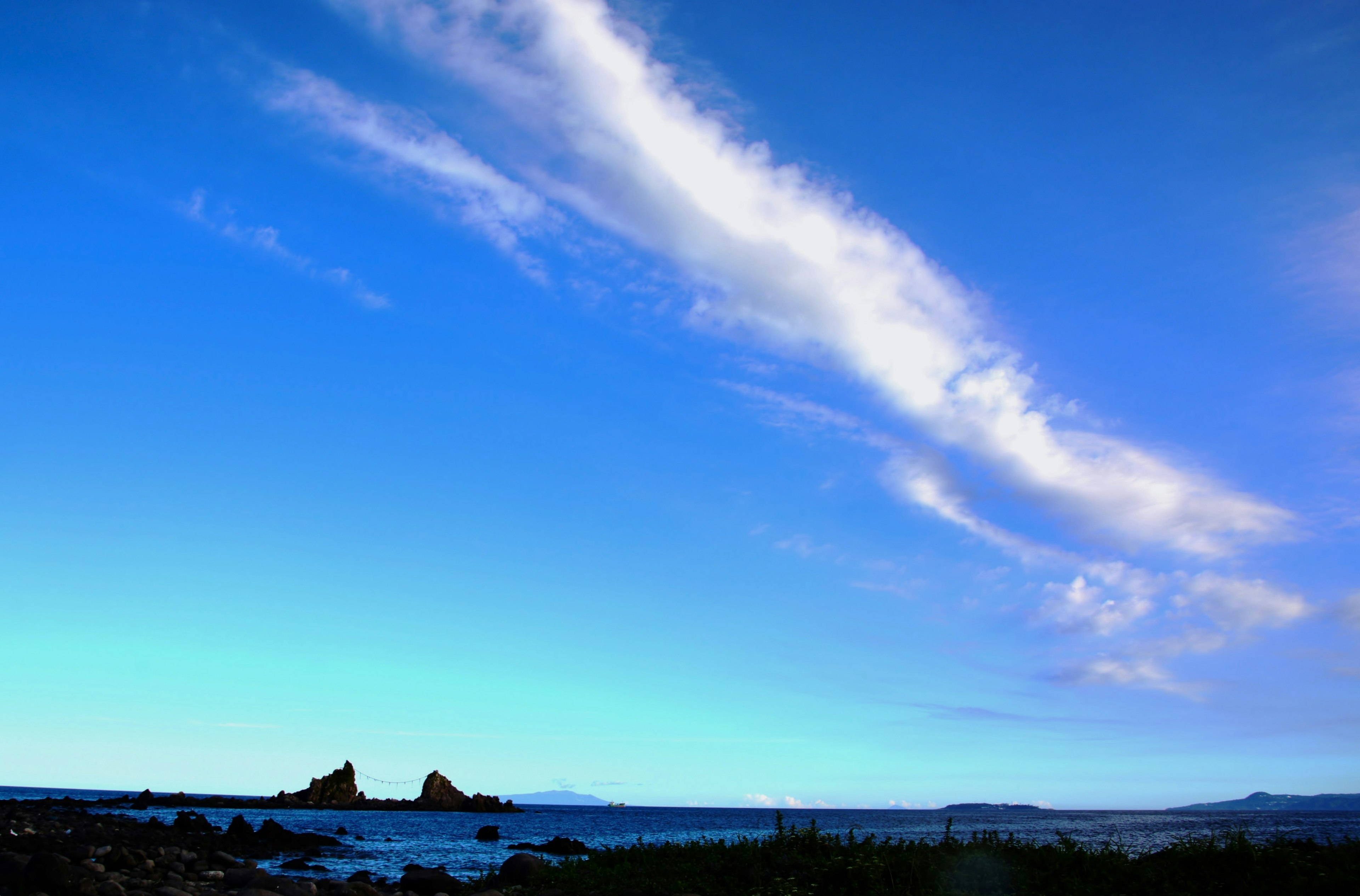 Küstenlandschaft mit blauem Himmel und weißen Wolken