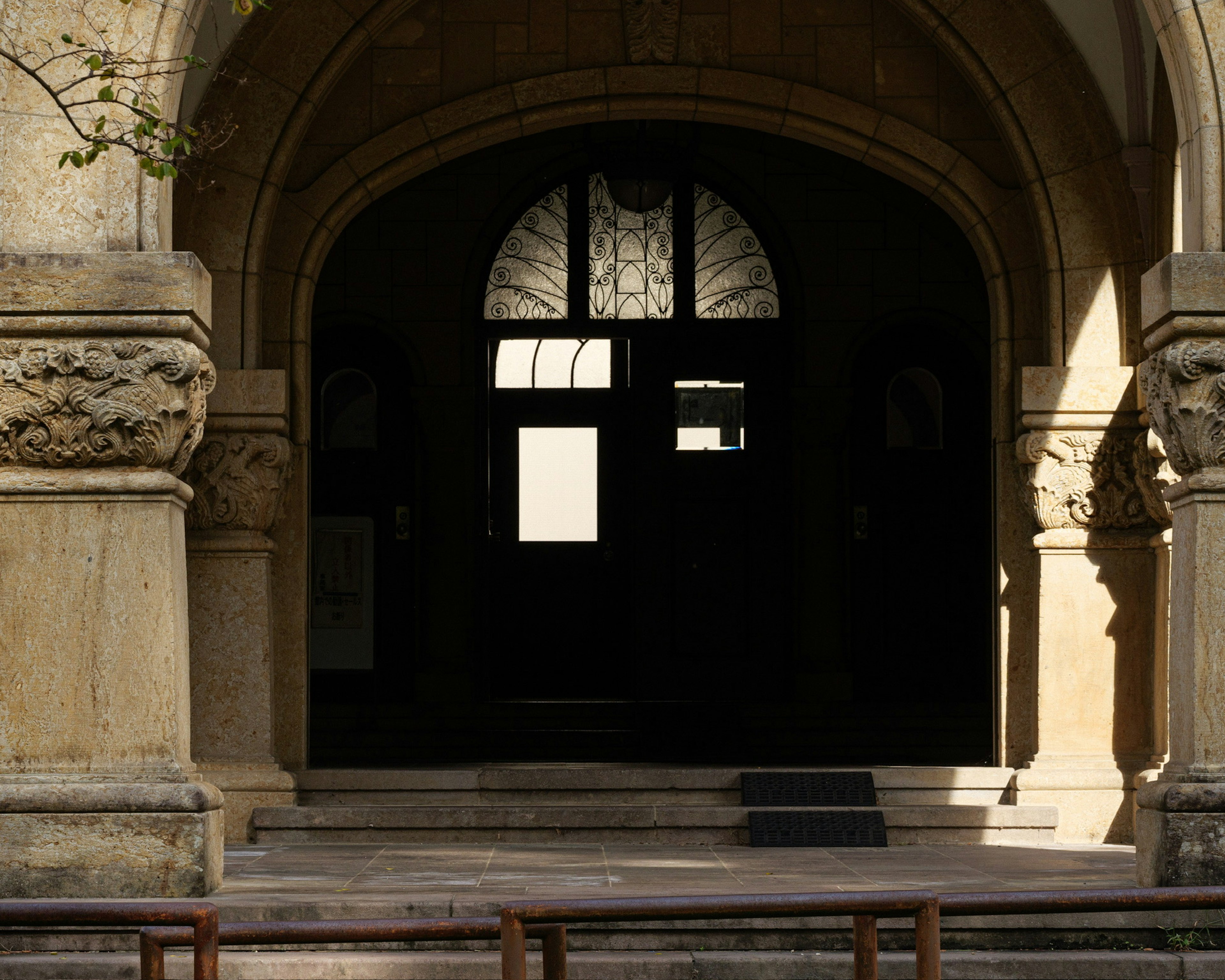 Entrance of a building featuring an arched doorway and decorative columns