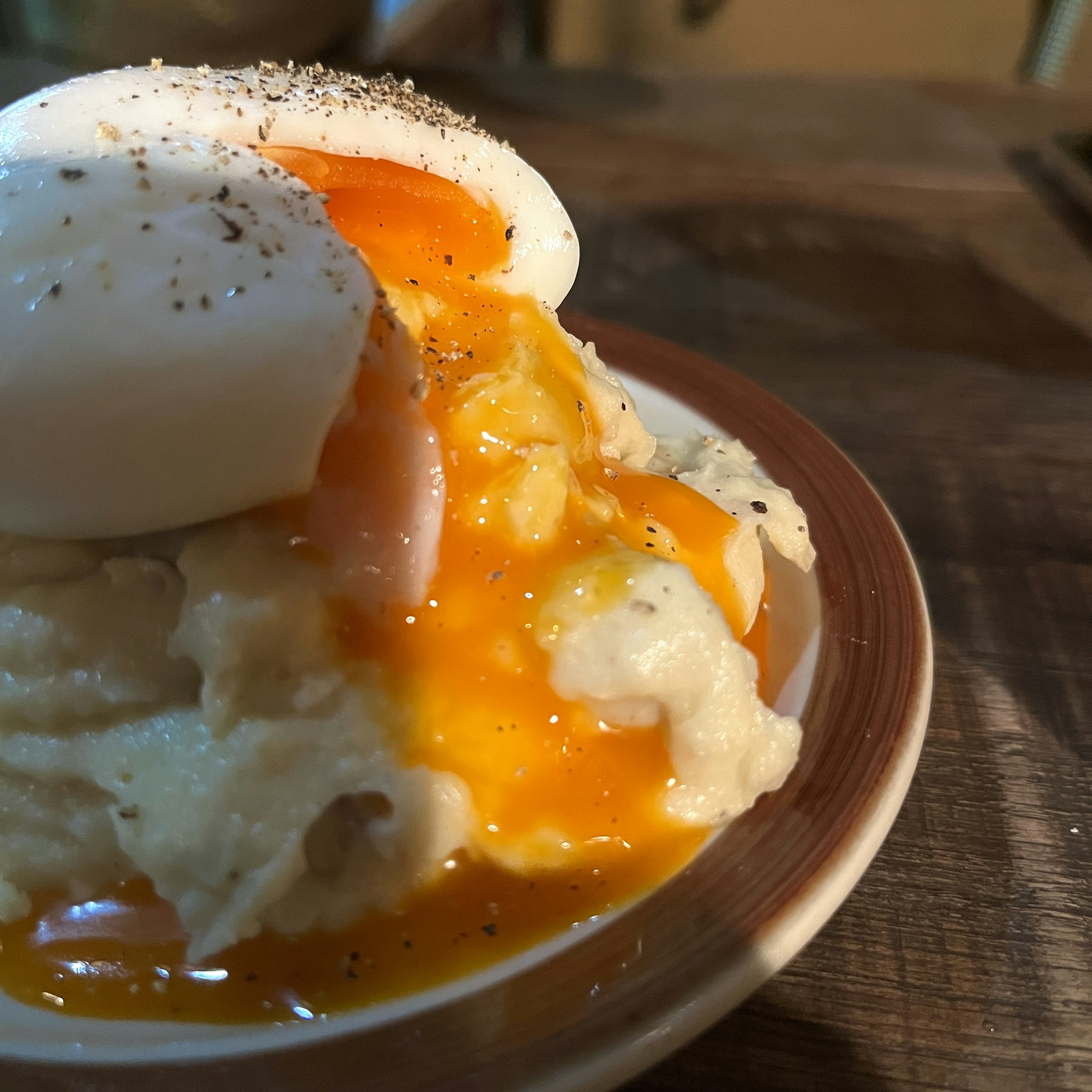 Close-up of creamy mashed potatoes topped with a runny egg