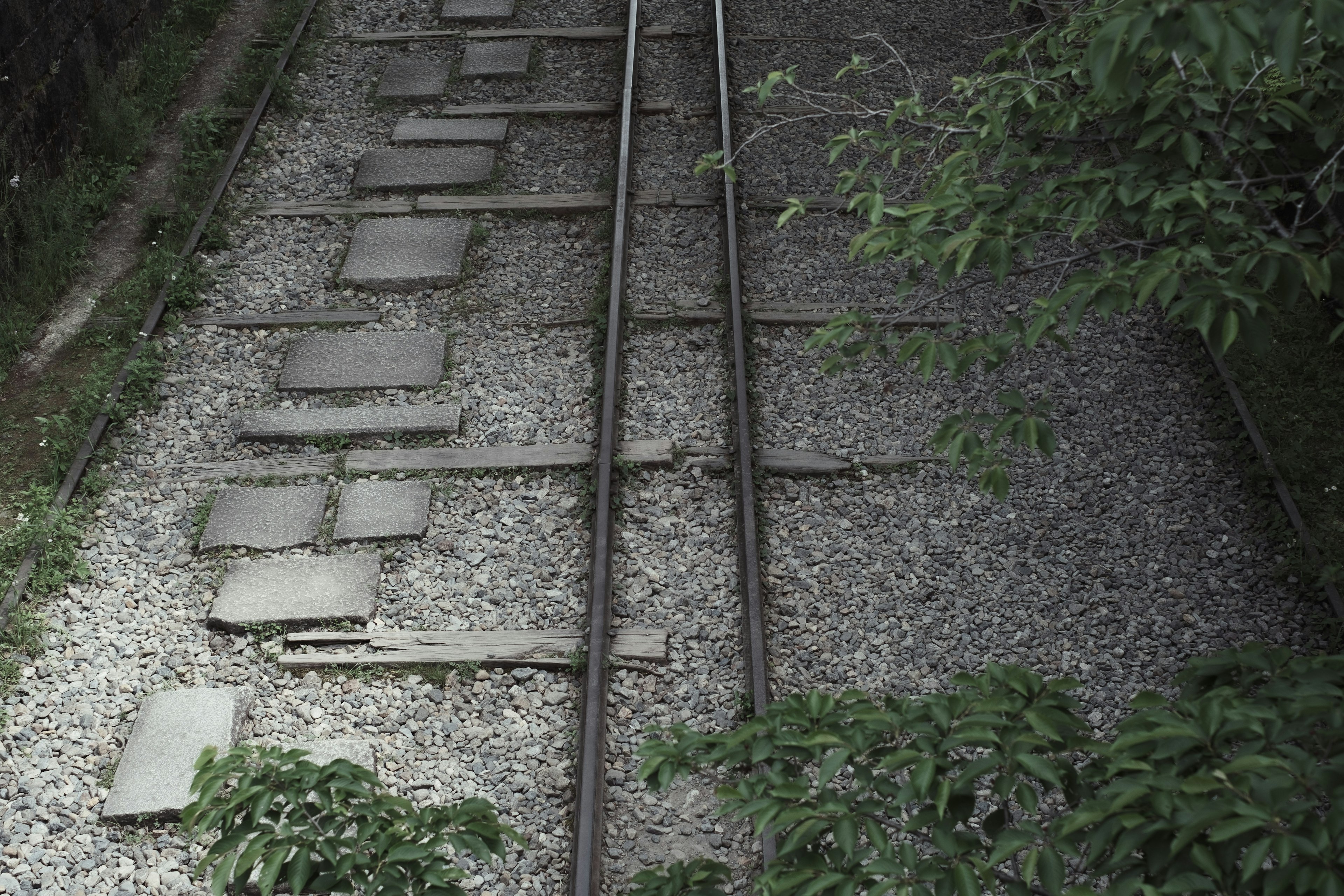 Aerial view of railway tracks with stone path and surrounding greenery