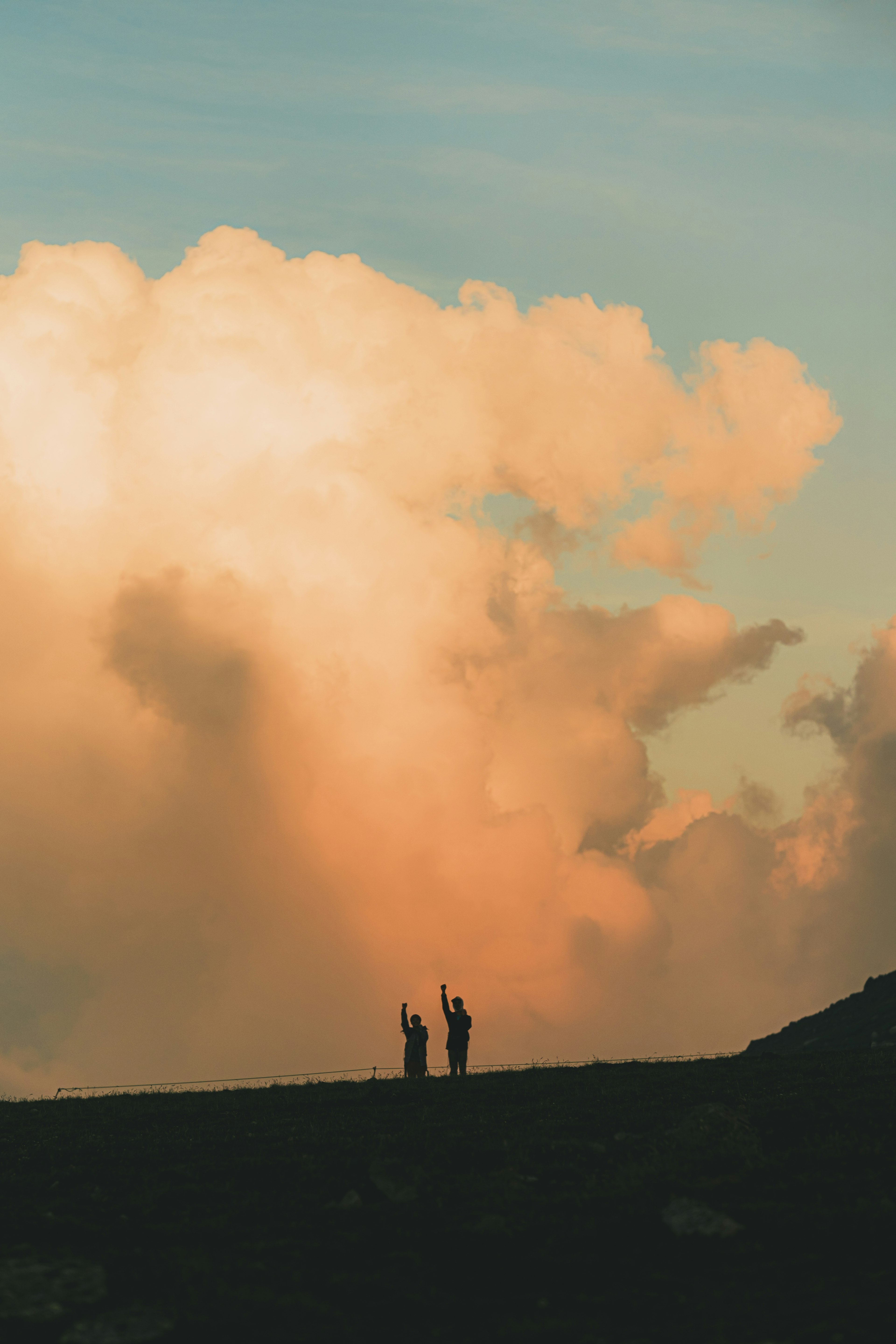 Silhouette de deux personnes devant un ciel de coucher de soleil