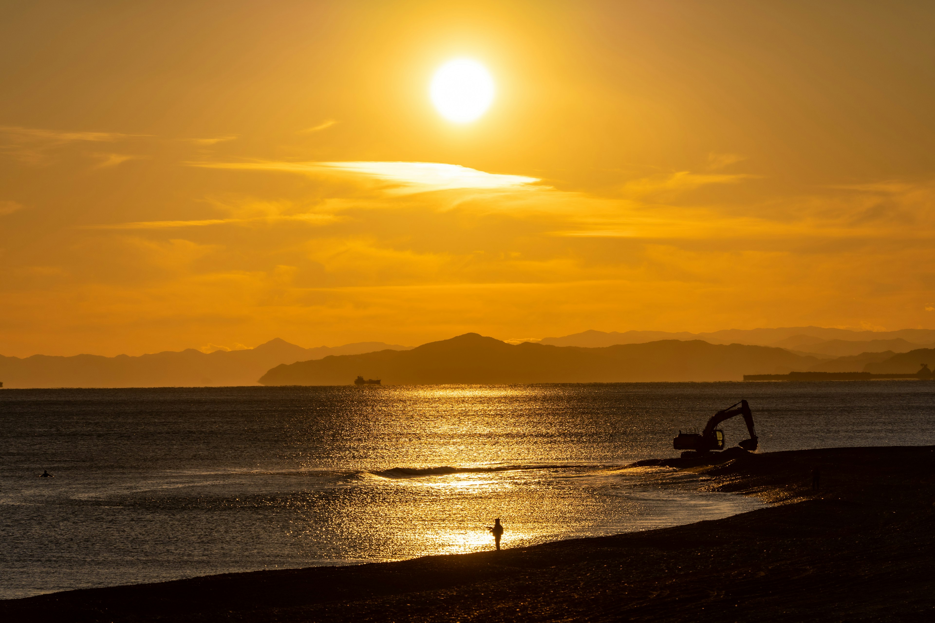 Beautiful landscape with sunset illuminating the sea and silhouette of a person