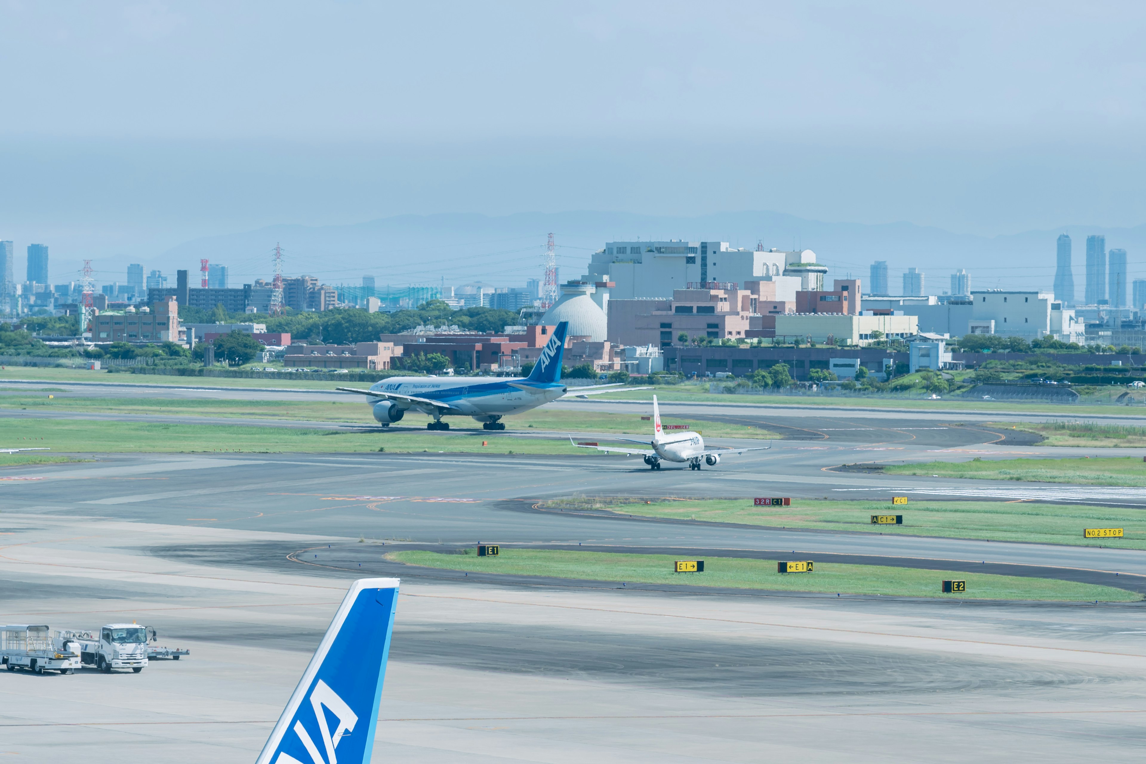 Airplane landing on runway with city skyline in background