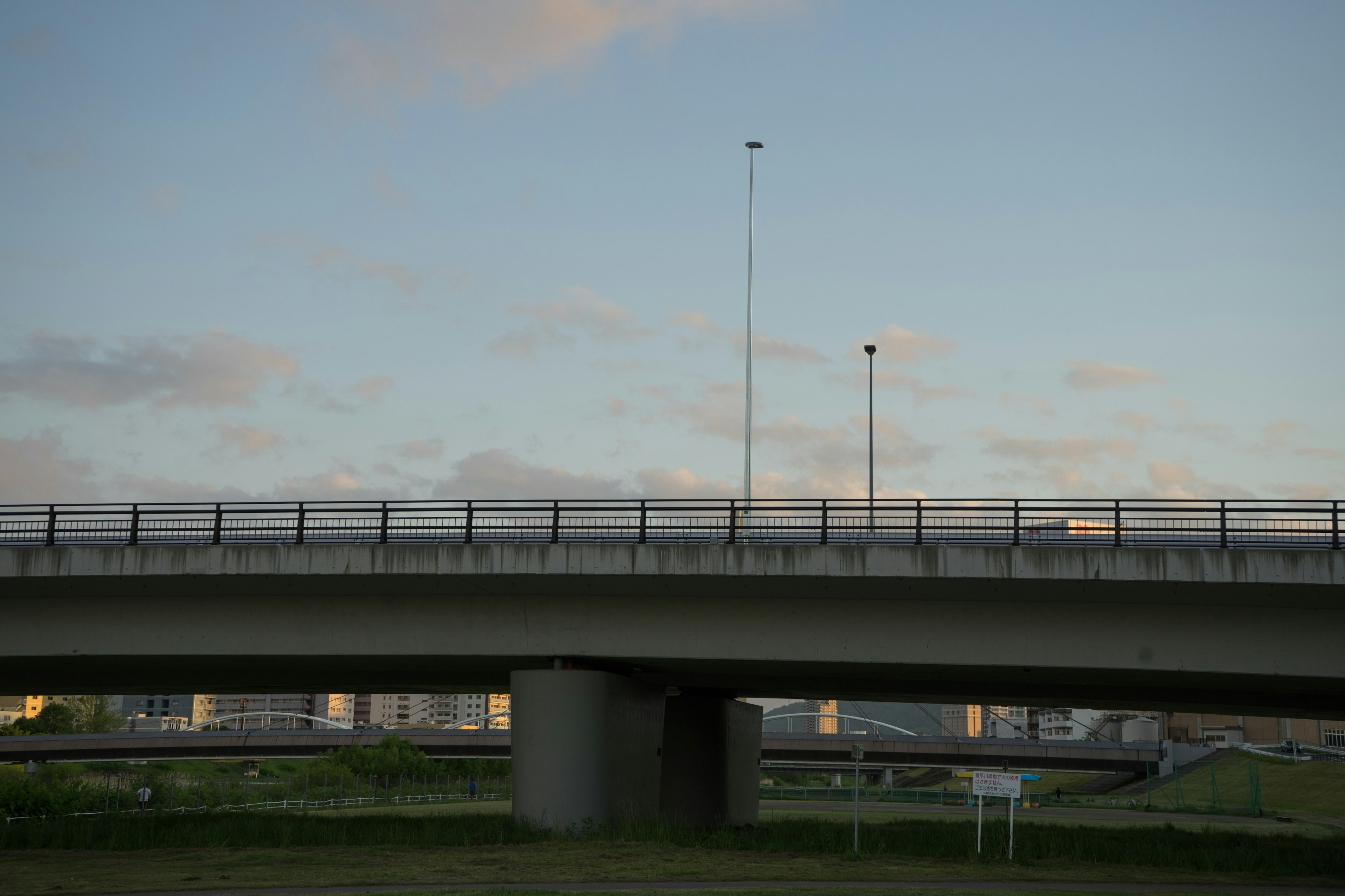 Blick von unter einer Brücke auf einen blauen Himmel mit leichten Wolken