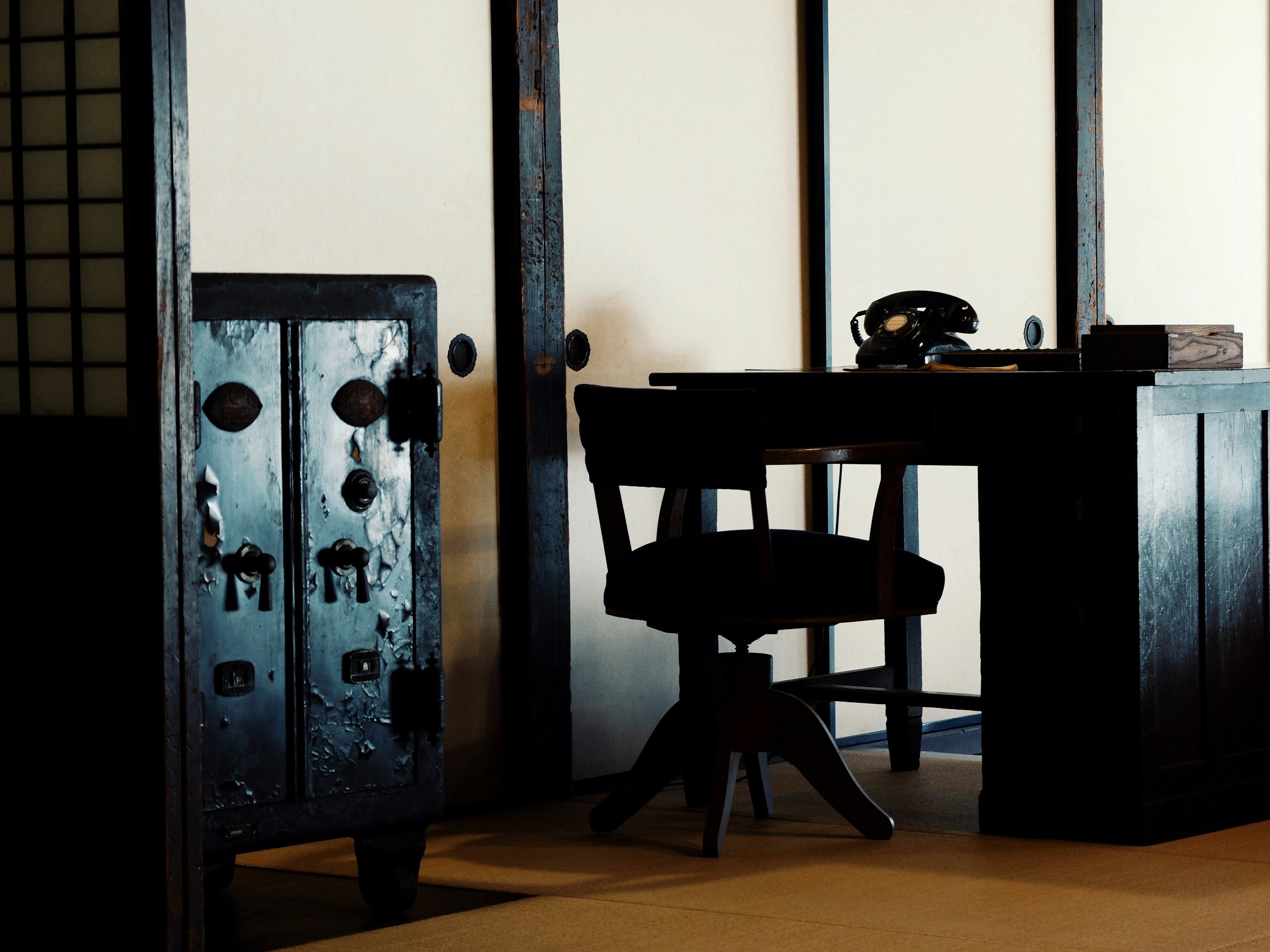 Espacio de oficina tranquilo con muebles negros y diseño de habitación japonesa tradicional