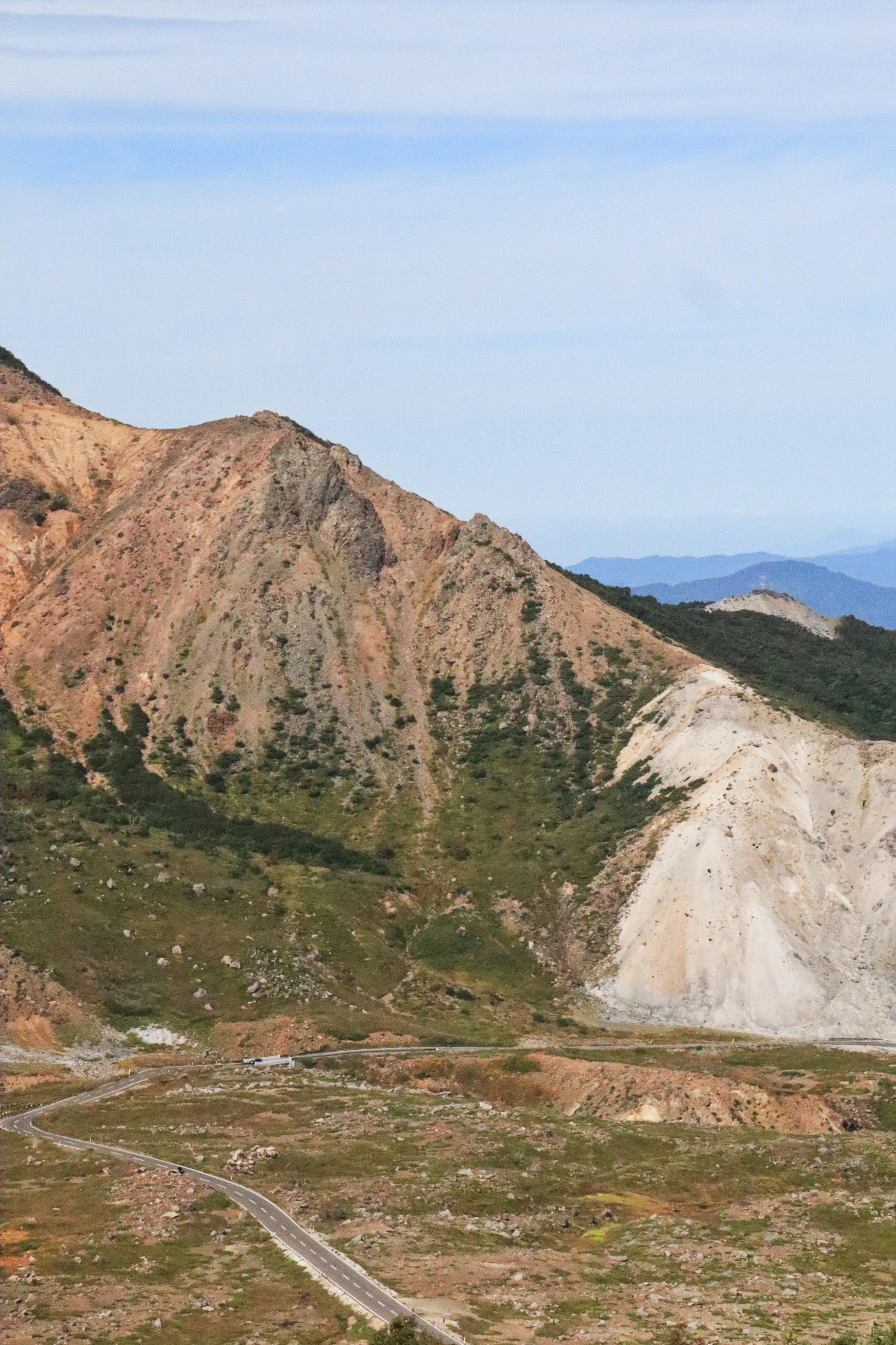 Bergneigung mit grünem Grasland und felsigem Terrain