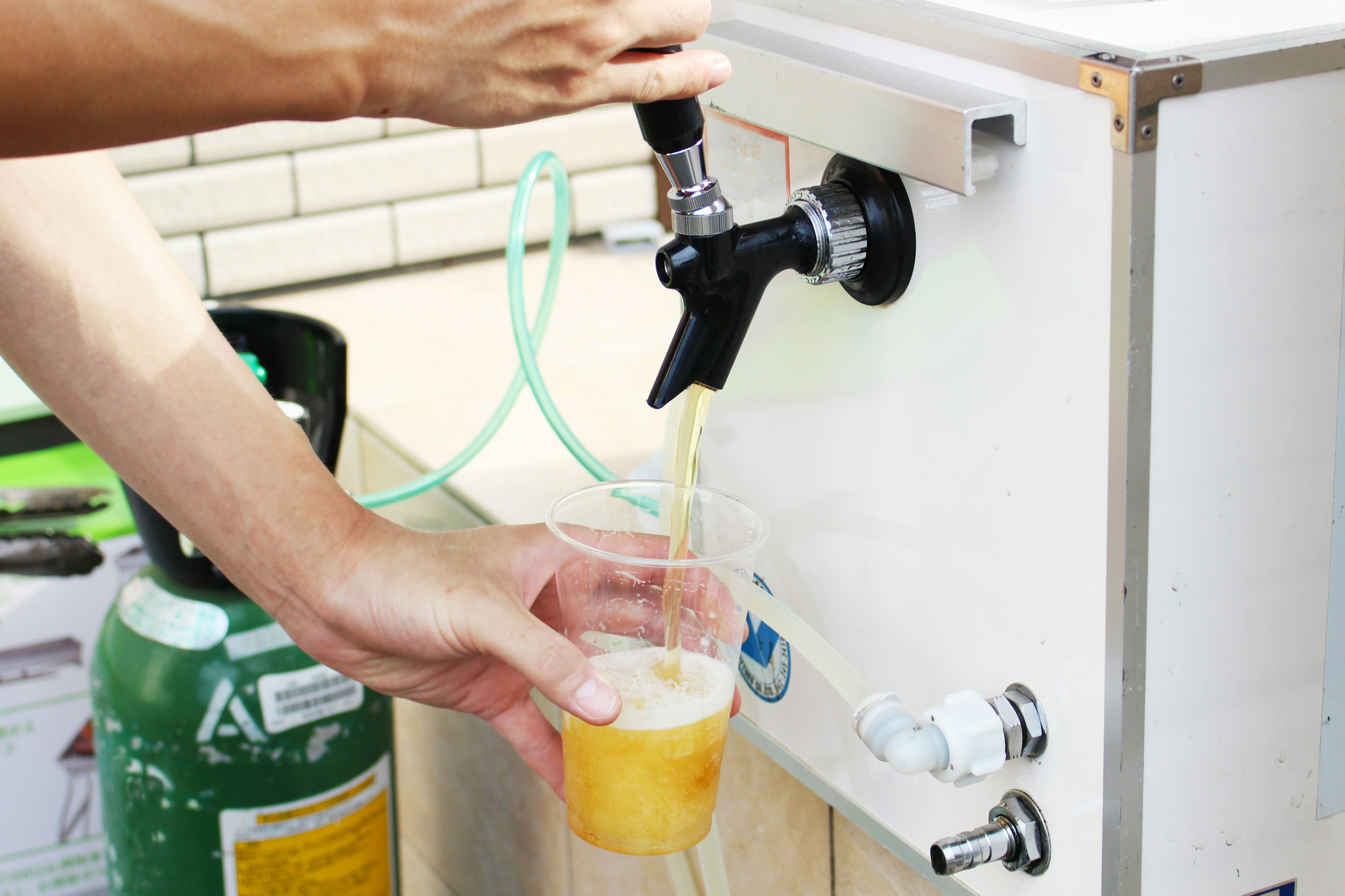 Image of a hand pouring beer from a tap into a cup