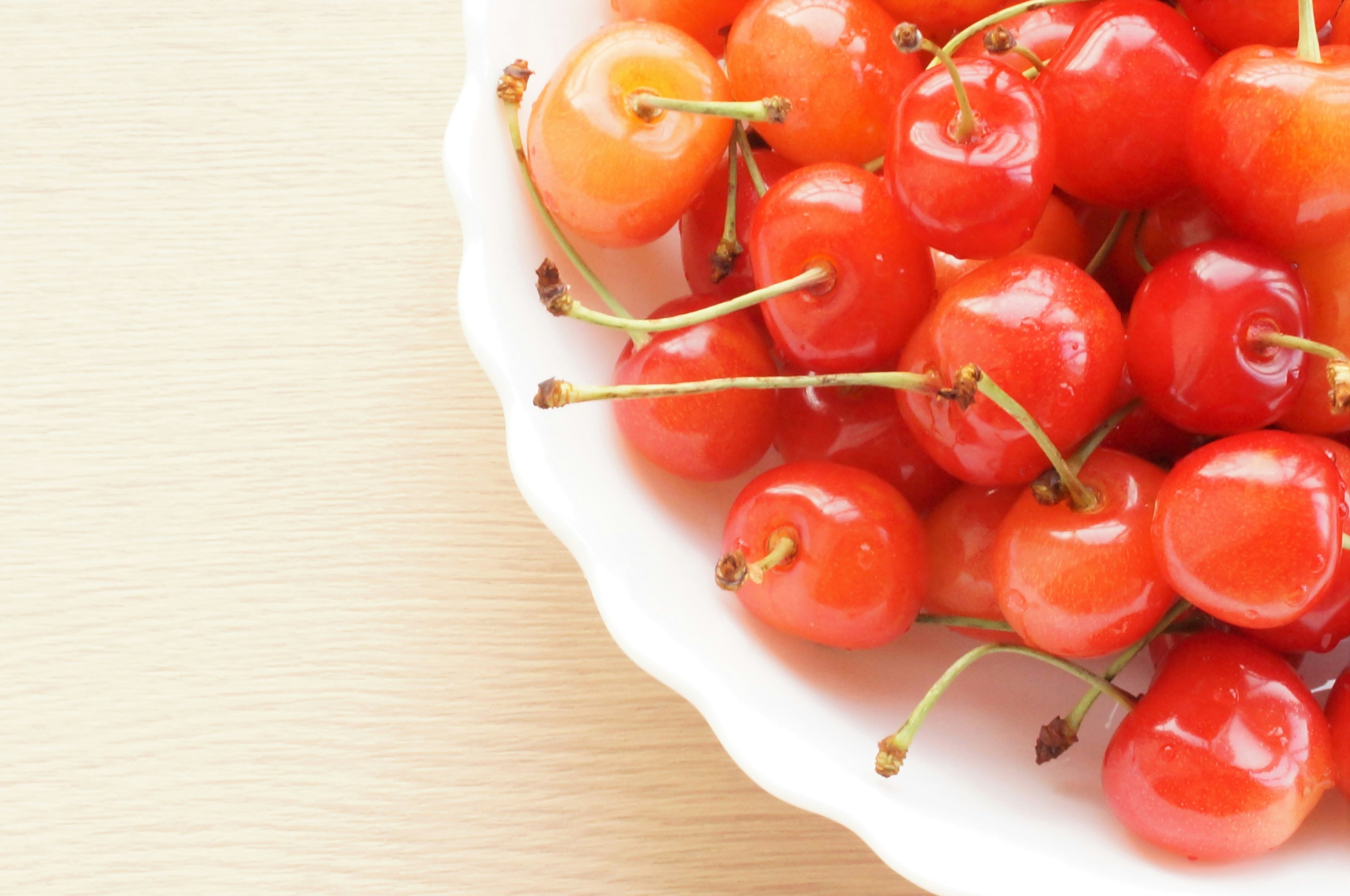 Close-up of red cherries in a white bowl