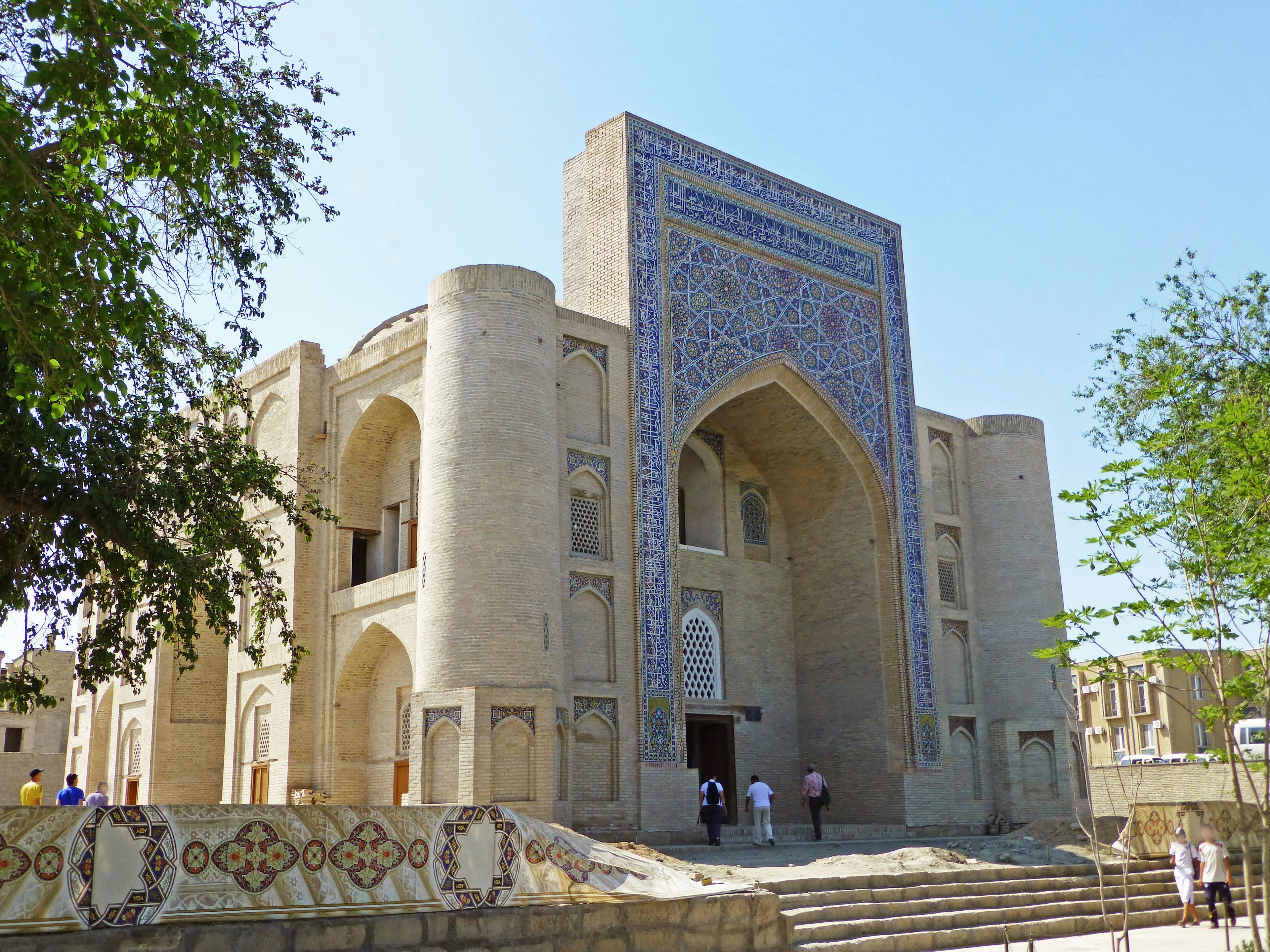 Vista esterna di un bell'edificio in Uzbekistan con decorazioni in piastrelle blu e grandi archi