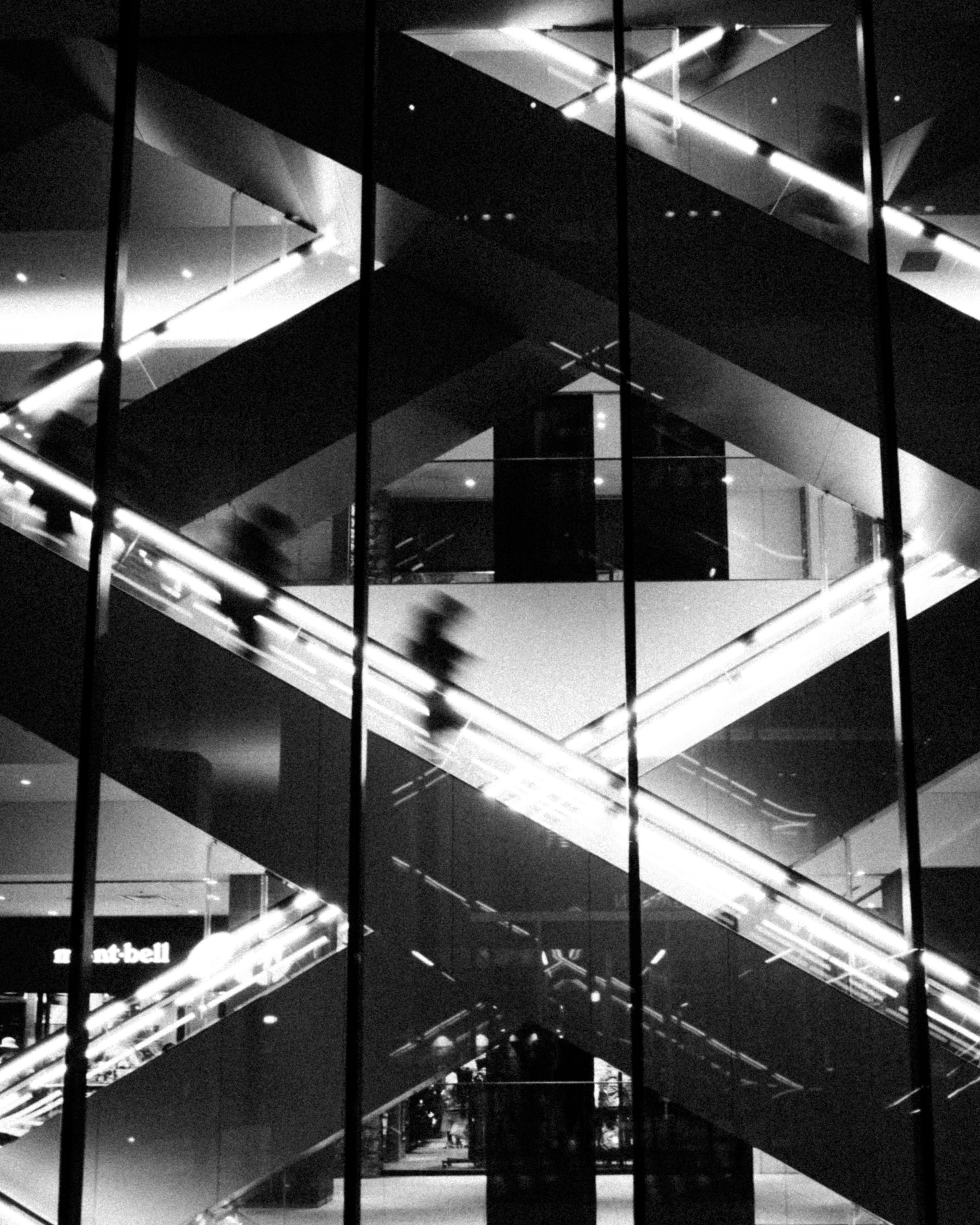 Modern interior structure in black and white featuring stylish escalators and glass walls