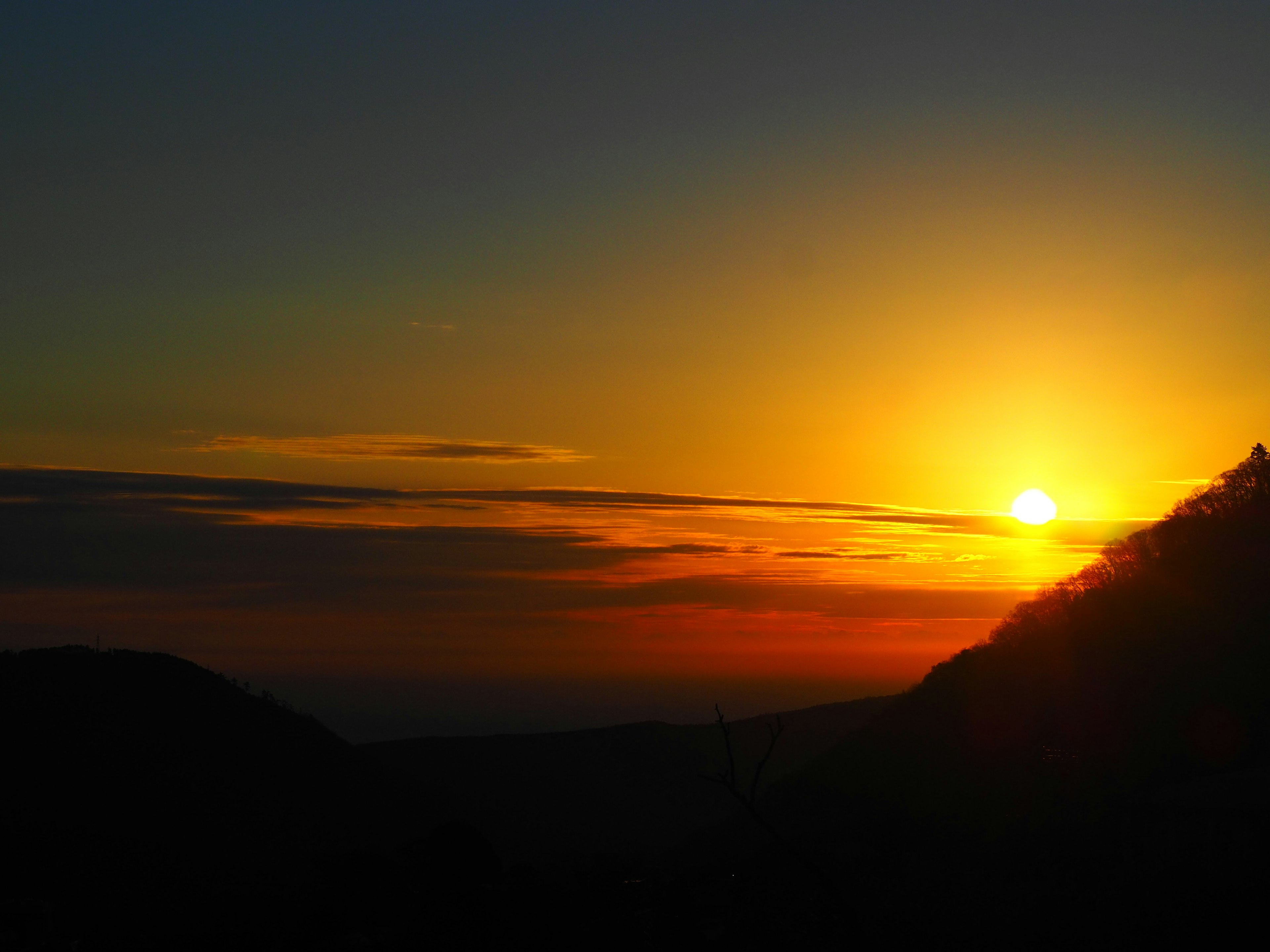 Schöne Sonnenuntergangsansicht mit Bergsilhouette und orangefarbenem Himmel