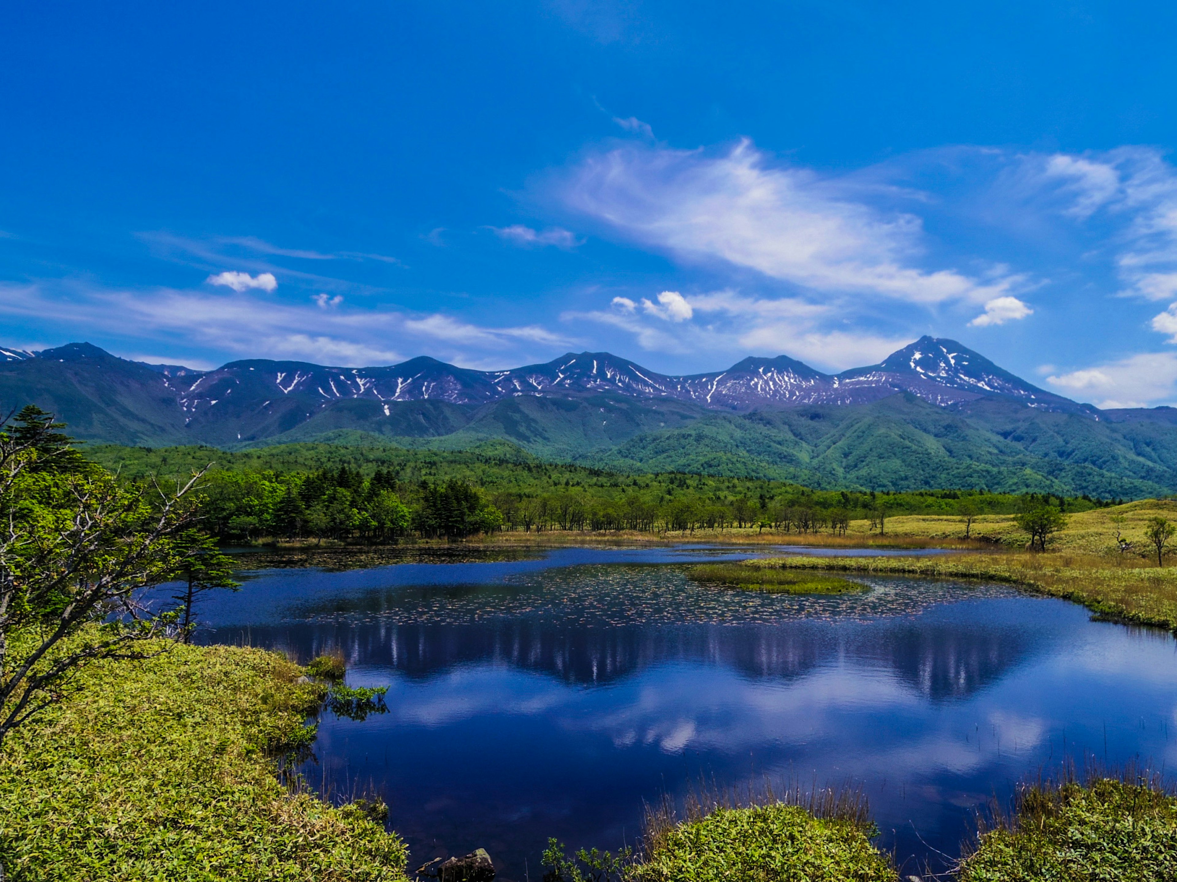 Serene lake landscape with snowy mountains and blue sky