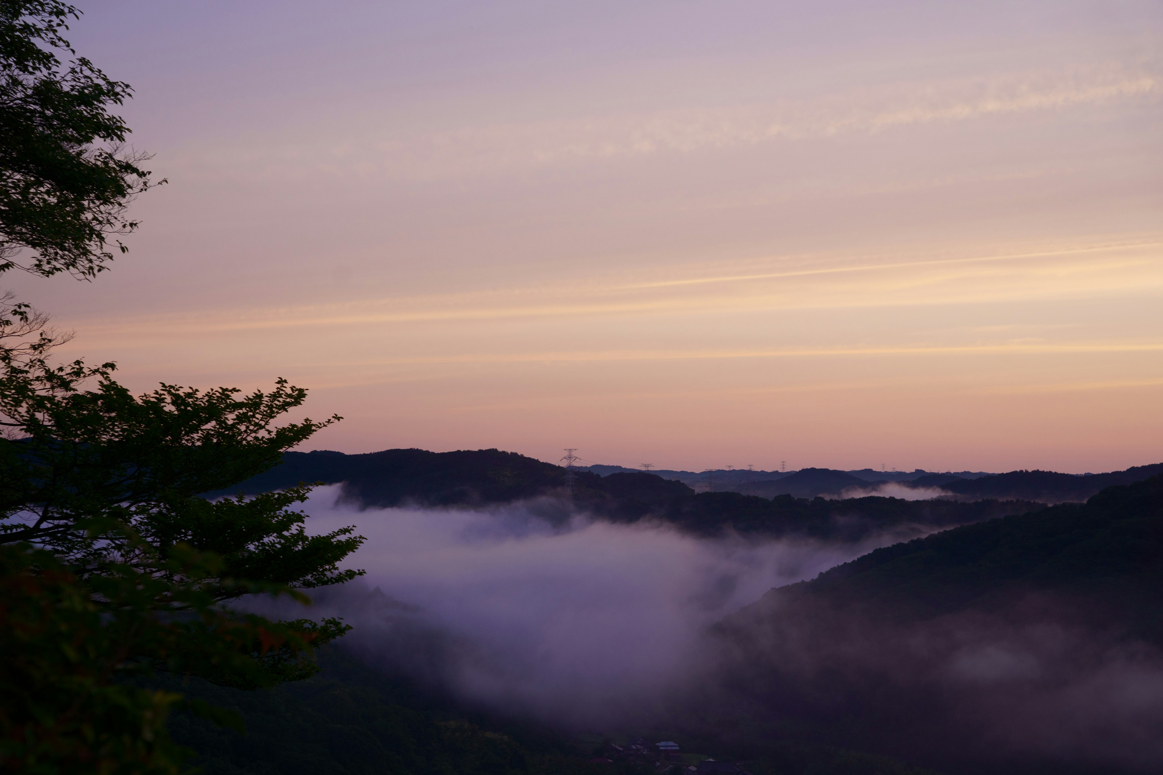 Hermoso paisaje de montañas cubiertas de niebla con un cielo púrpura