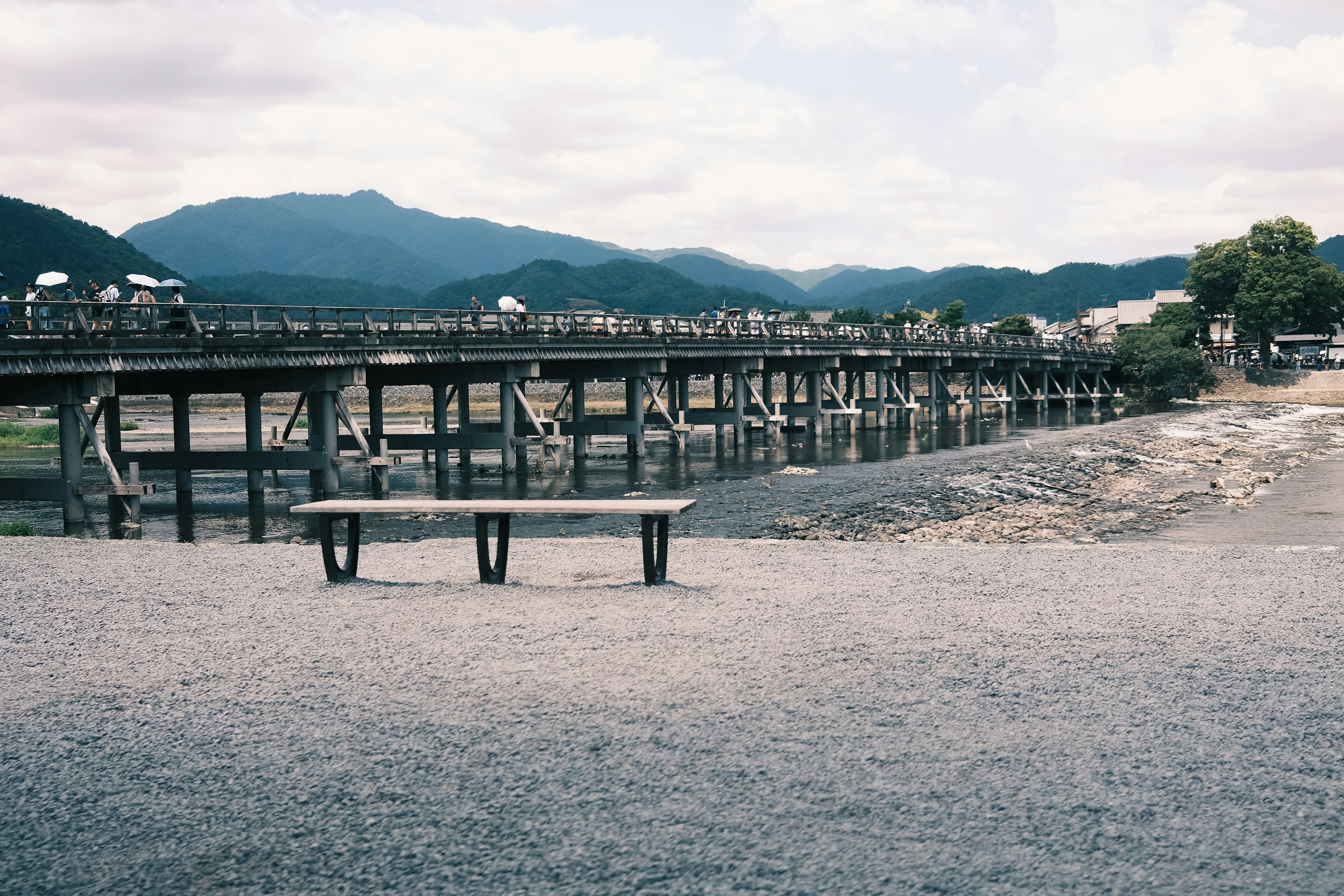 川の近くの木製の橋とベンチの風景