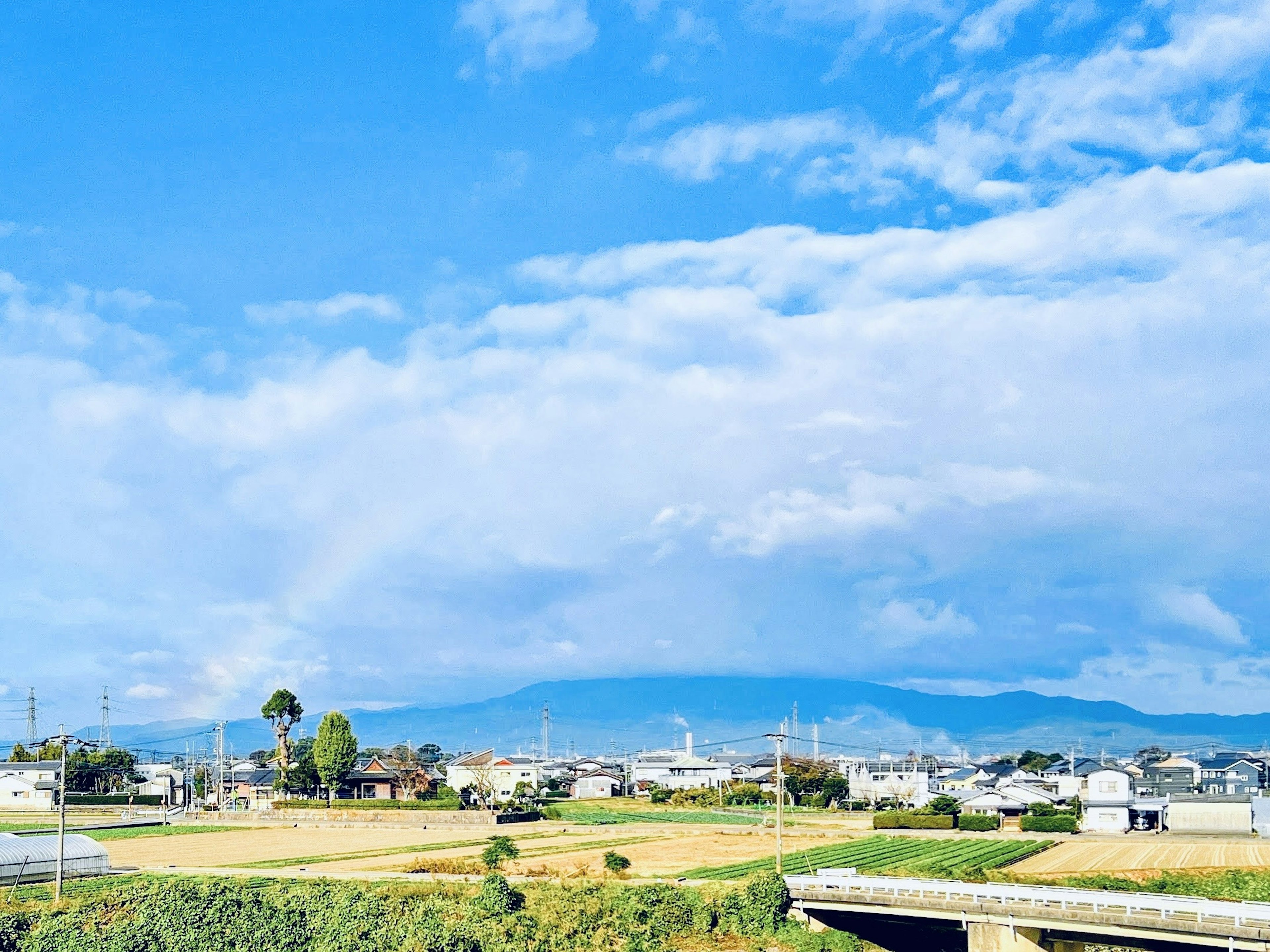 藍天和雲下的廣闊農村景觀與山脈