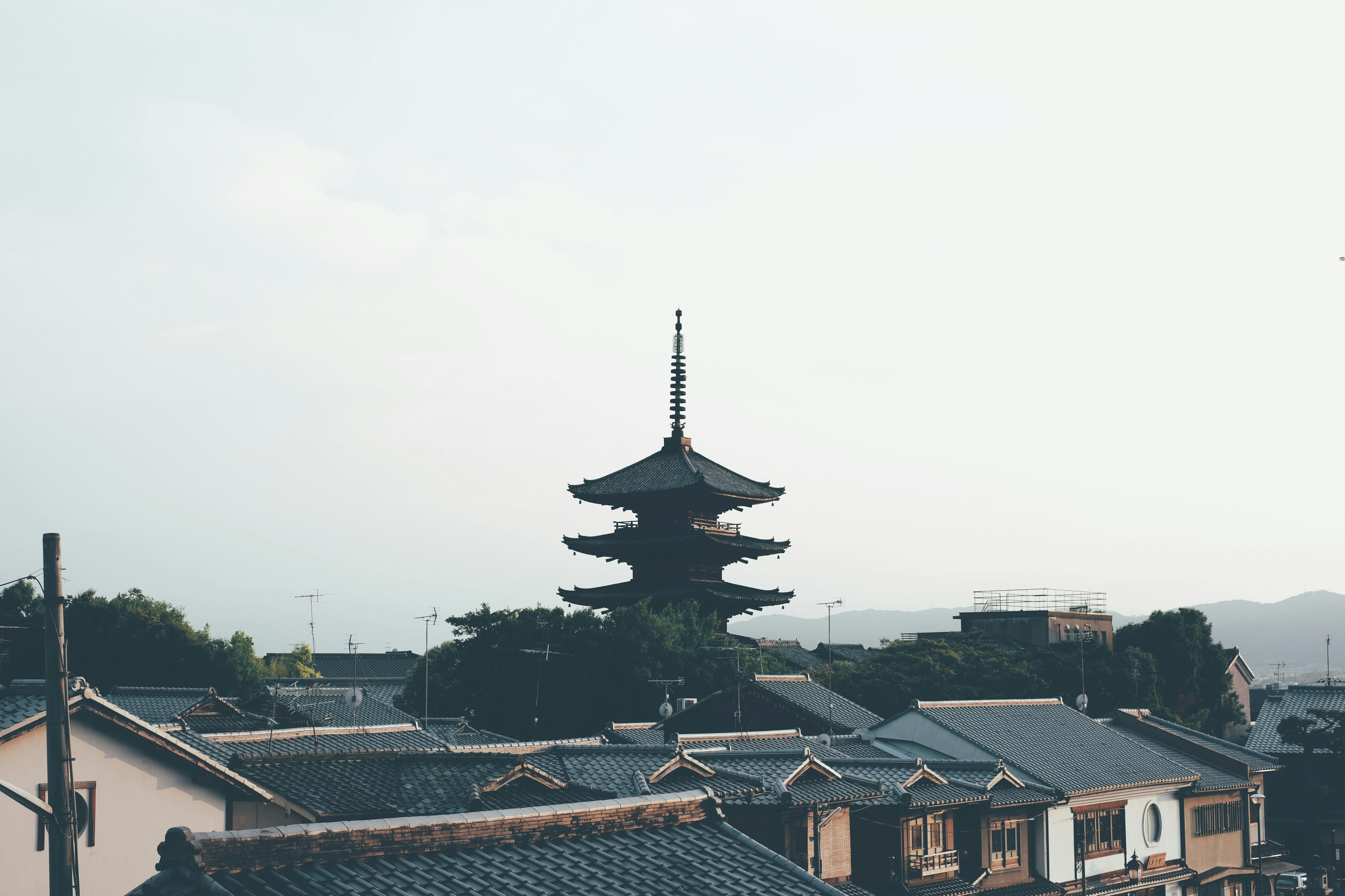 Blick auf eine fünfstöckige Pagode vor dem Hintergrund einer alten japanischen Stadt