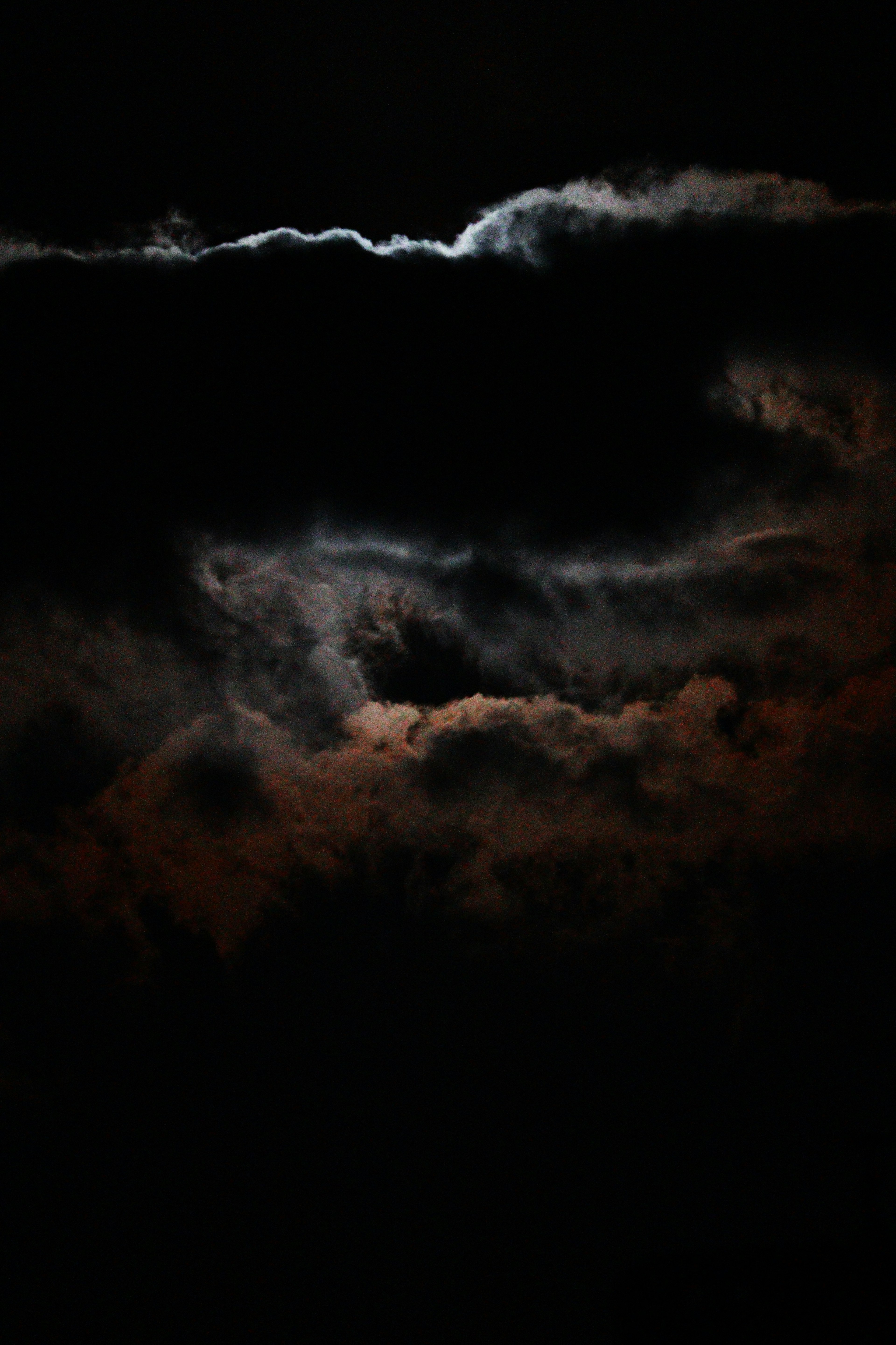 Nubes contrastantes iluminadas por una luz tenue en un cielo oscuro