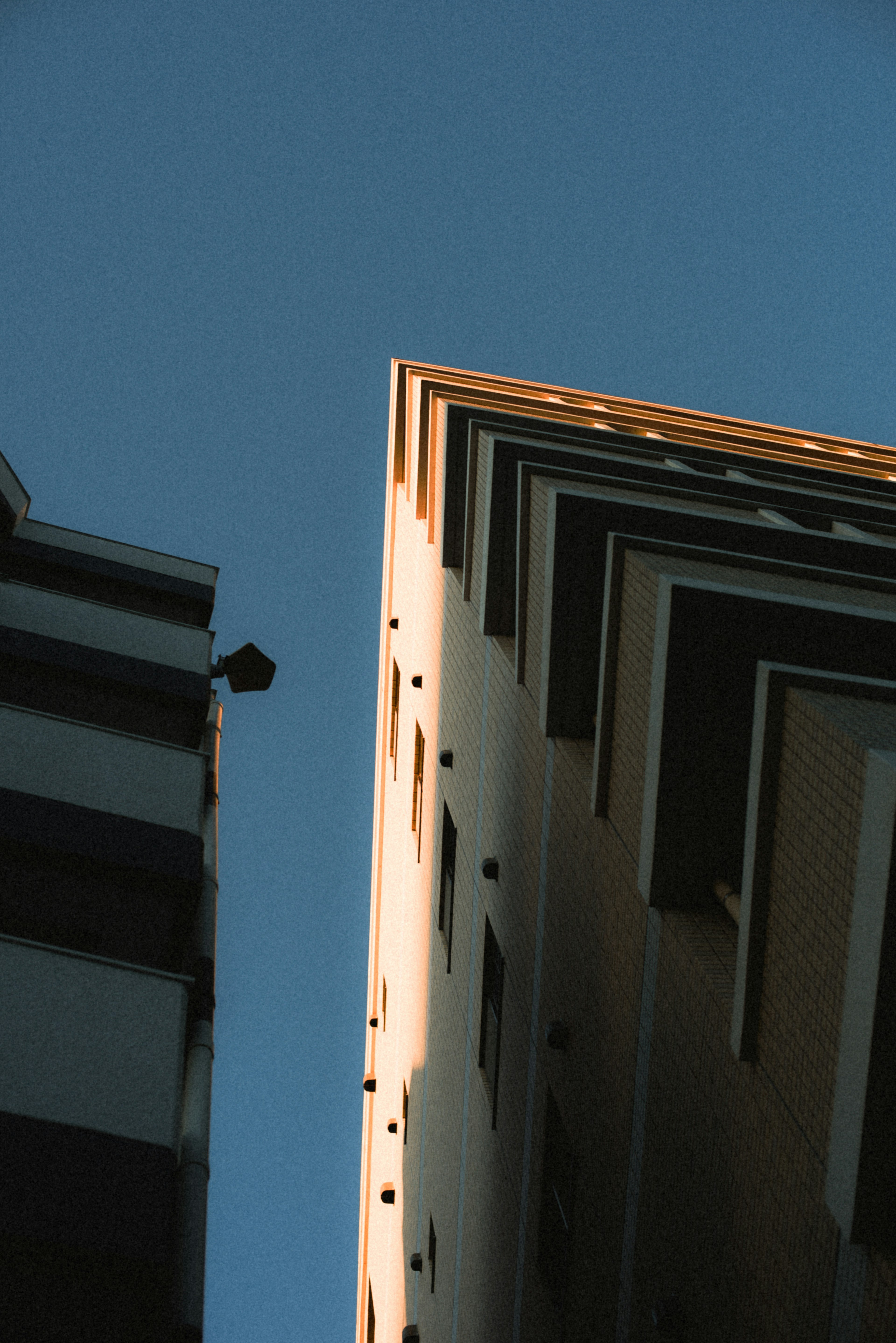 Sharp angled view of a building against a blue sky