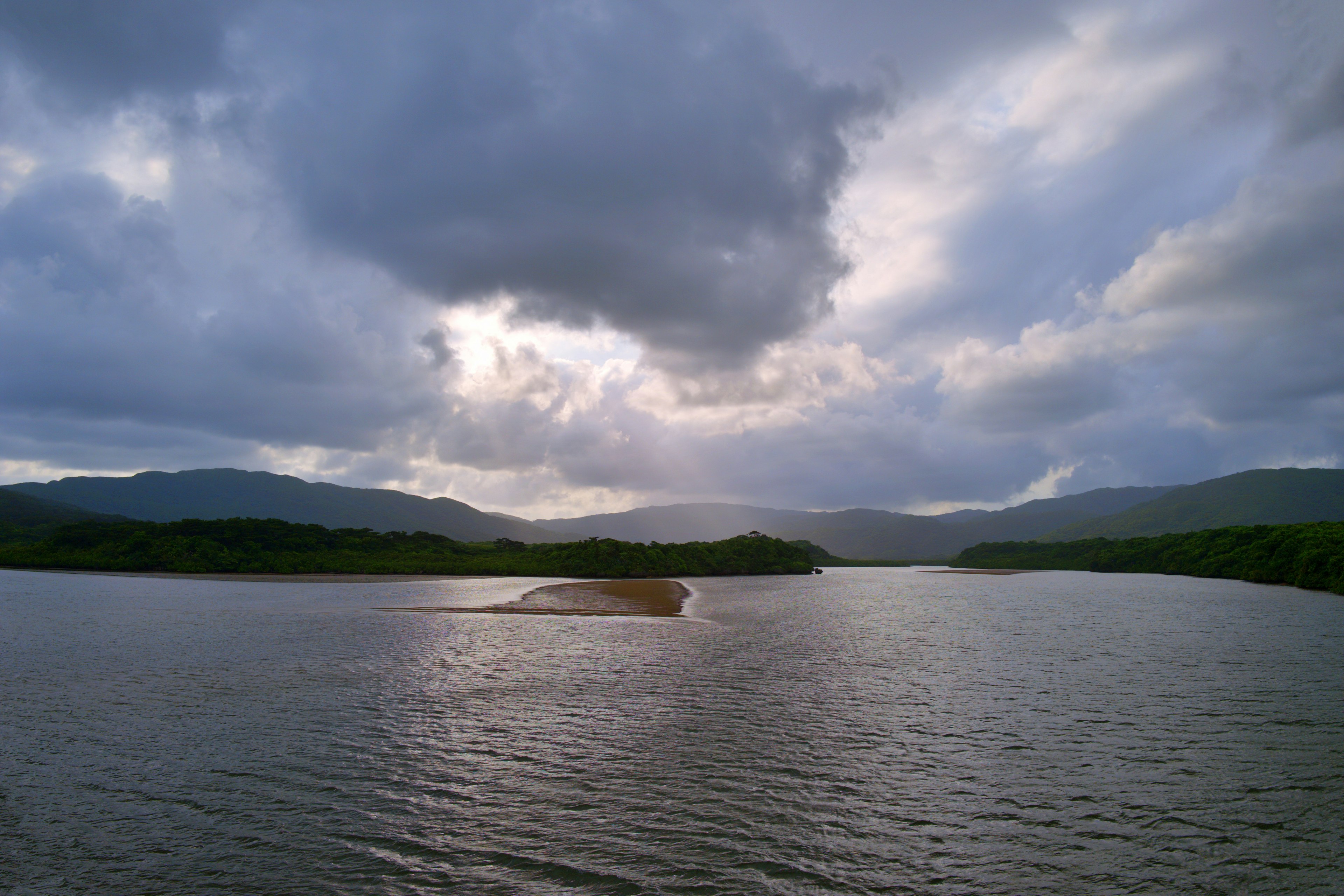 静かな湖と山々の風景　曇った空と水面の反射