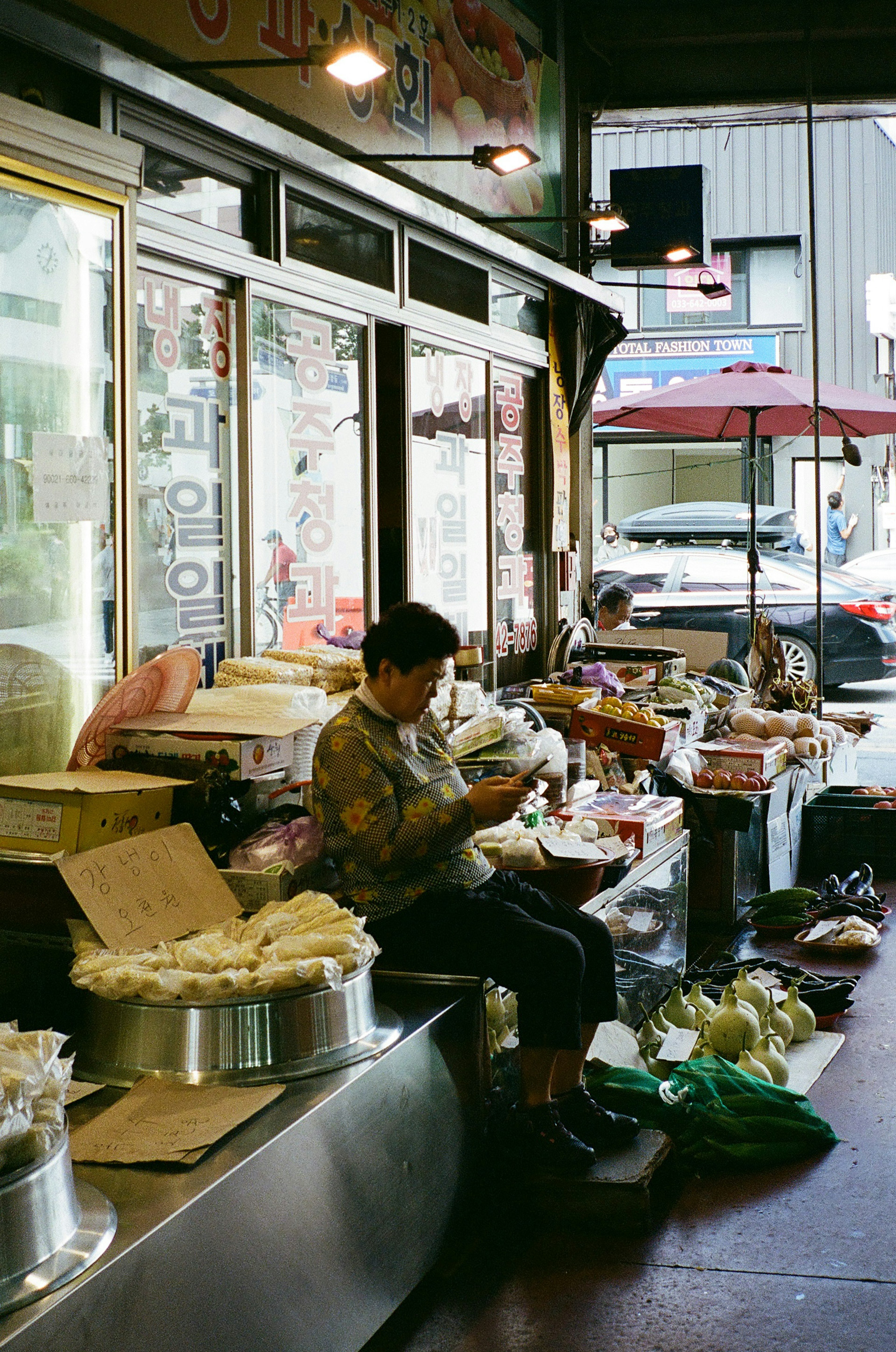 Man working in a market surrounded by various food items