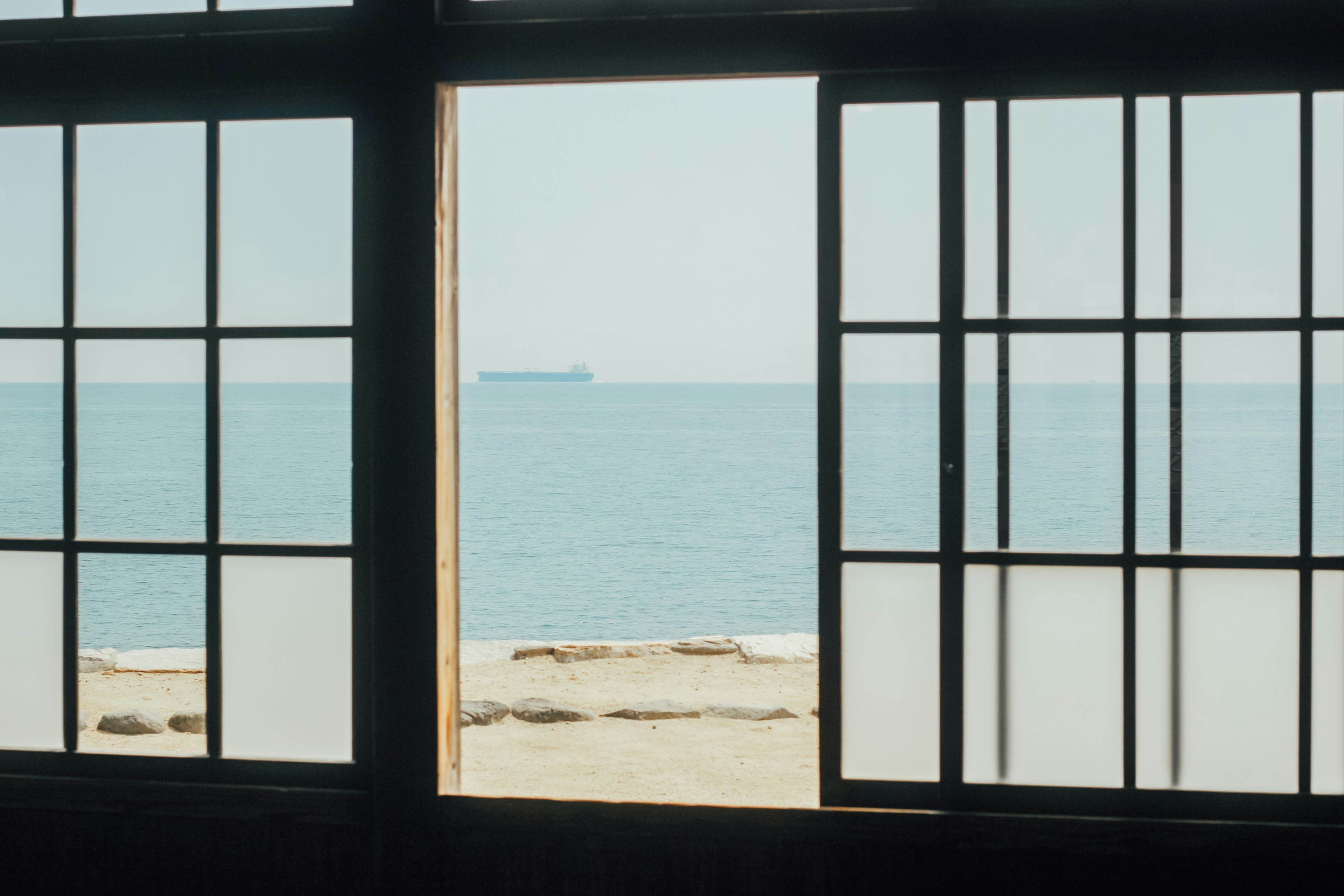 Japanese-style window framing a serene ocean view