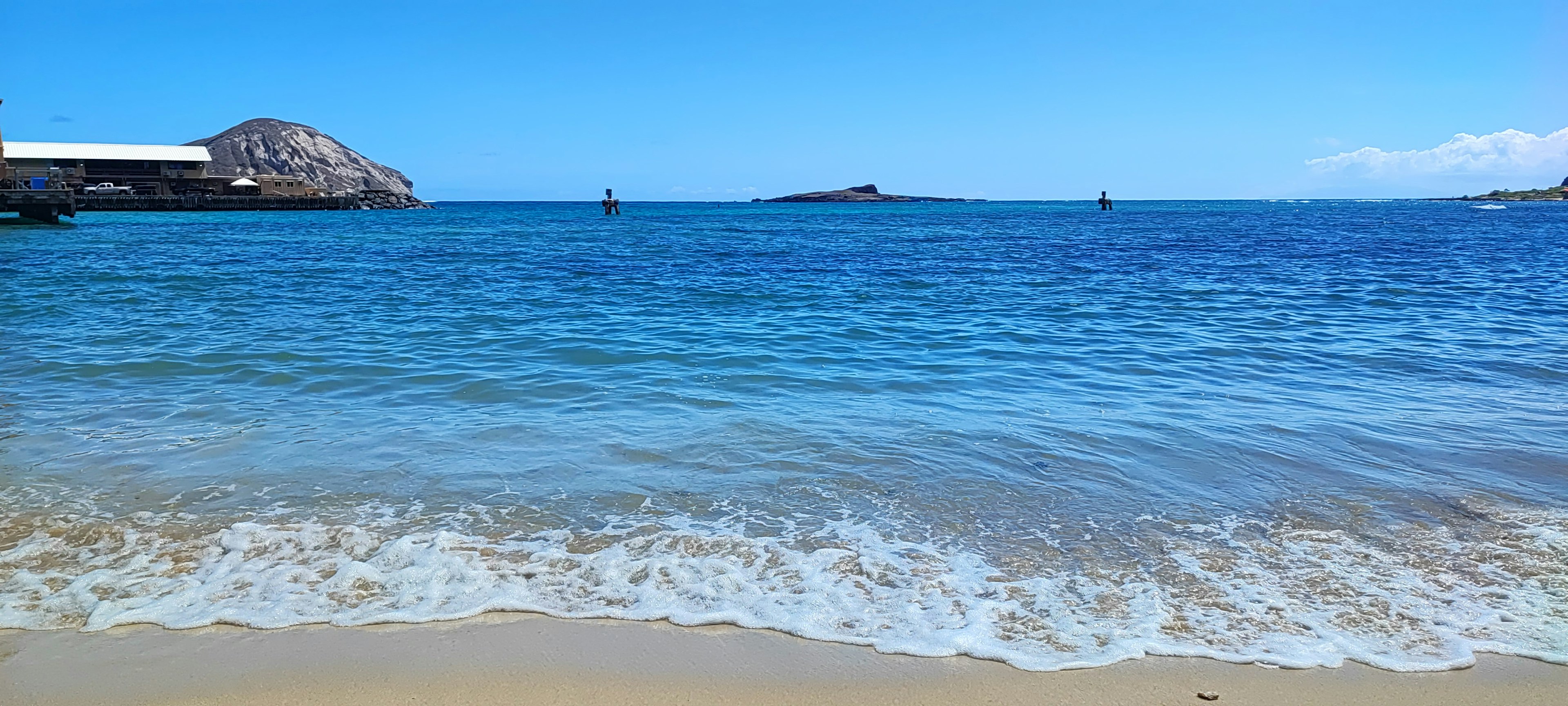 藍色海洋和沙灘的風景，遠處有小島