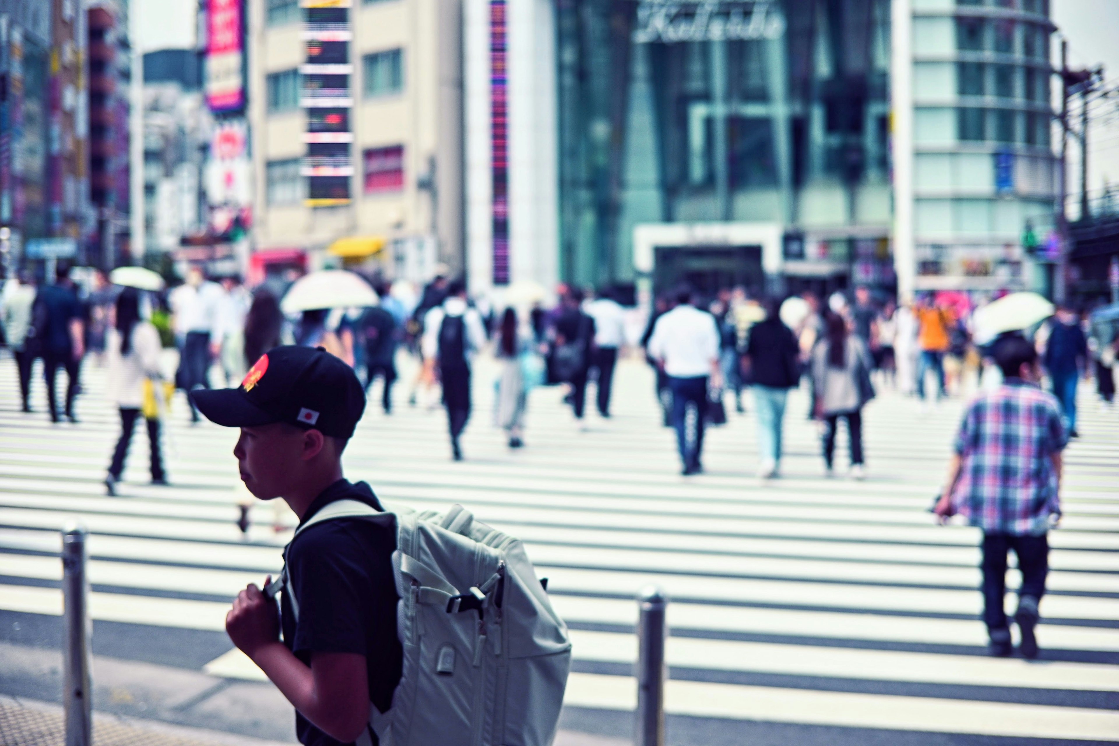 人々が横断歩道を渡る都市の風景若い男性がリュックを背負っている