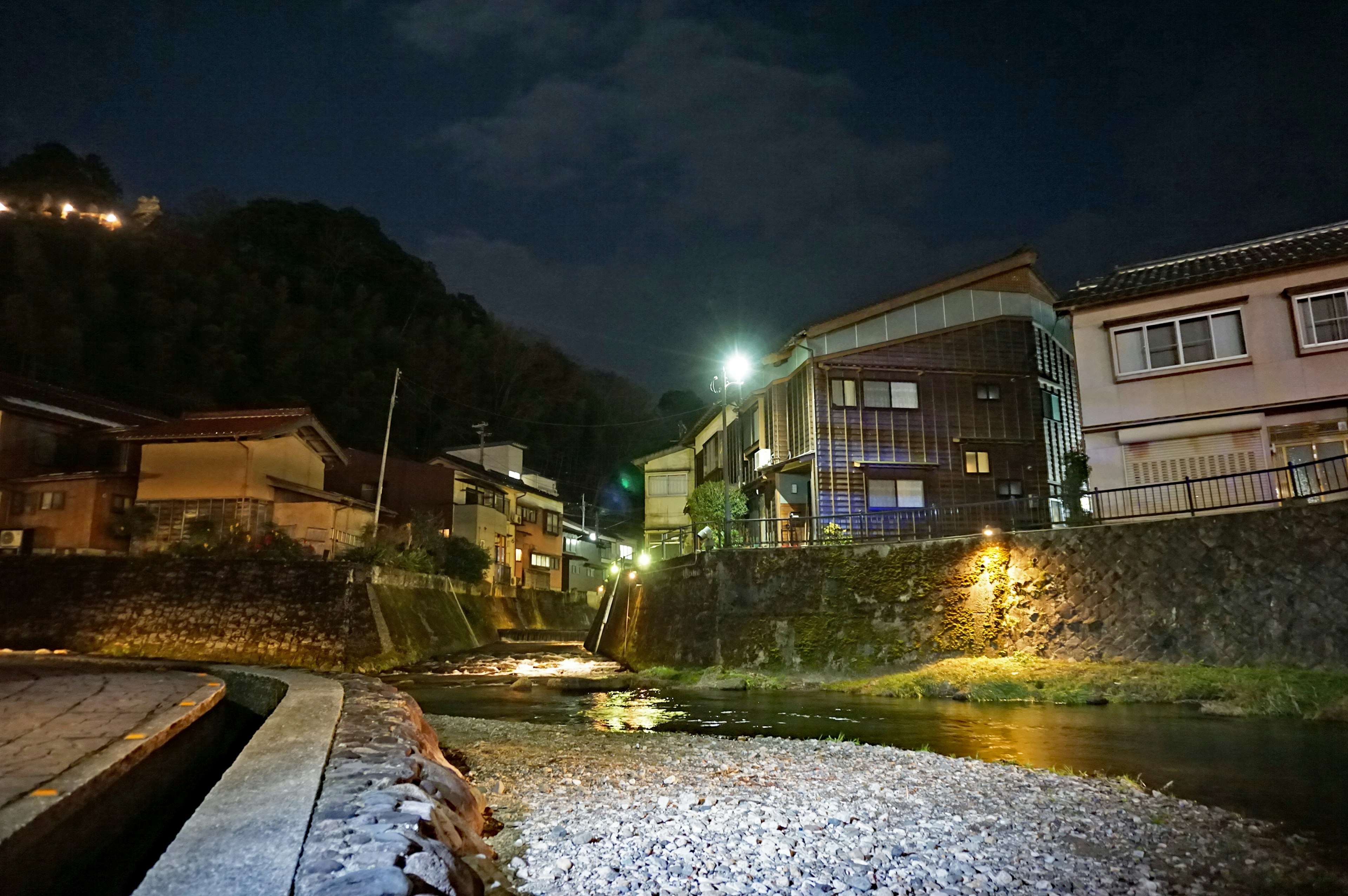 夜間燈光照亮的寧靜河邊房屋