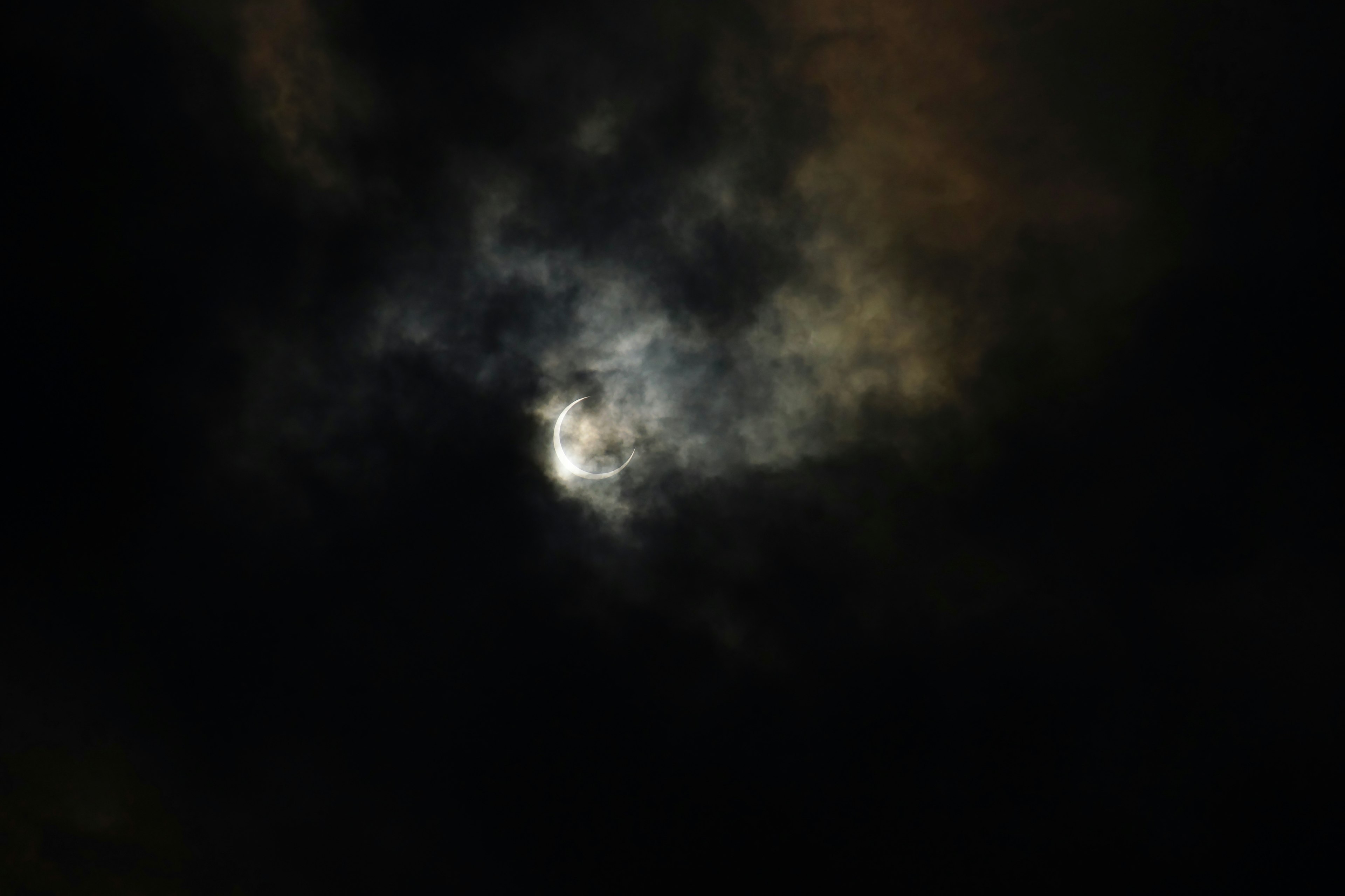 lueur de lune brillante visible à travers des nuages sombres