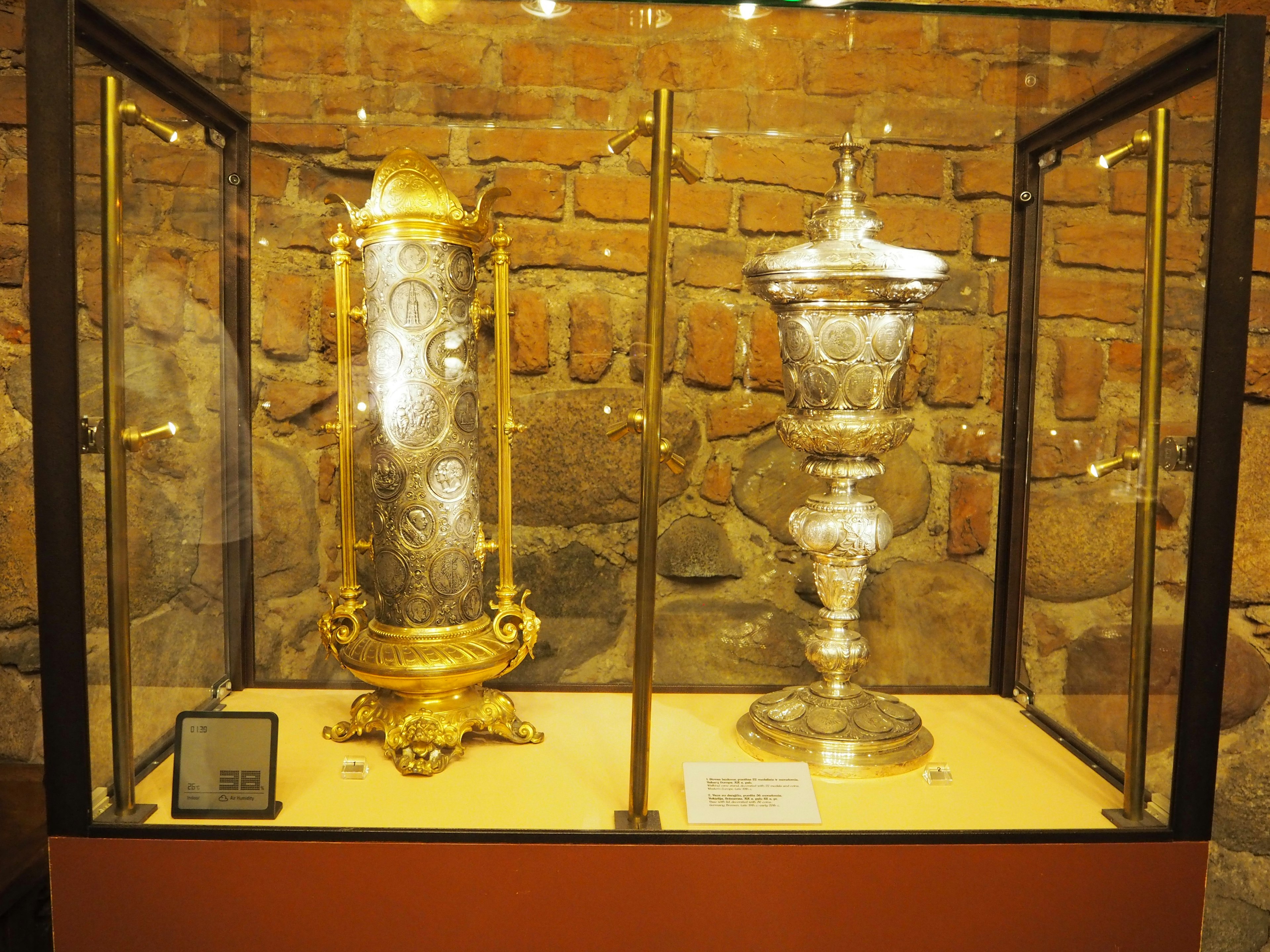 Decorative gold and silver objects displayed in a glass case