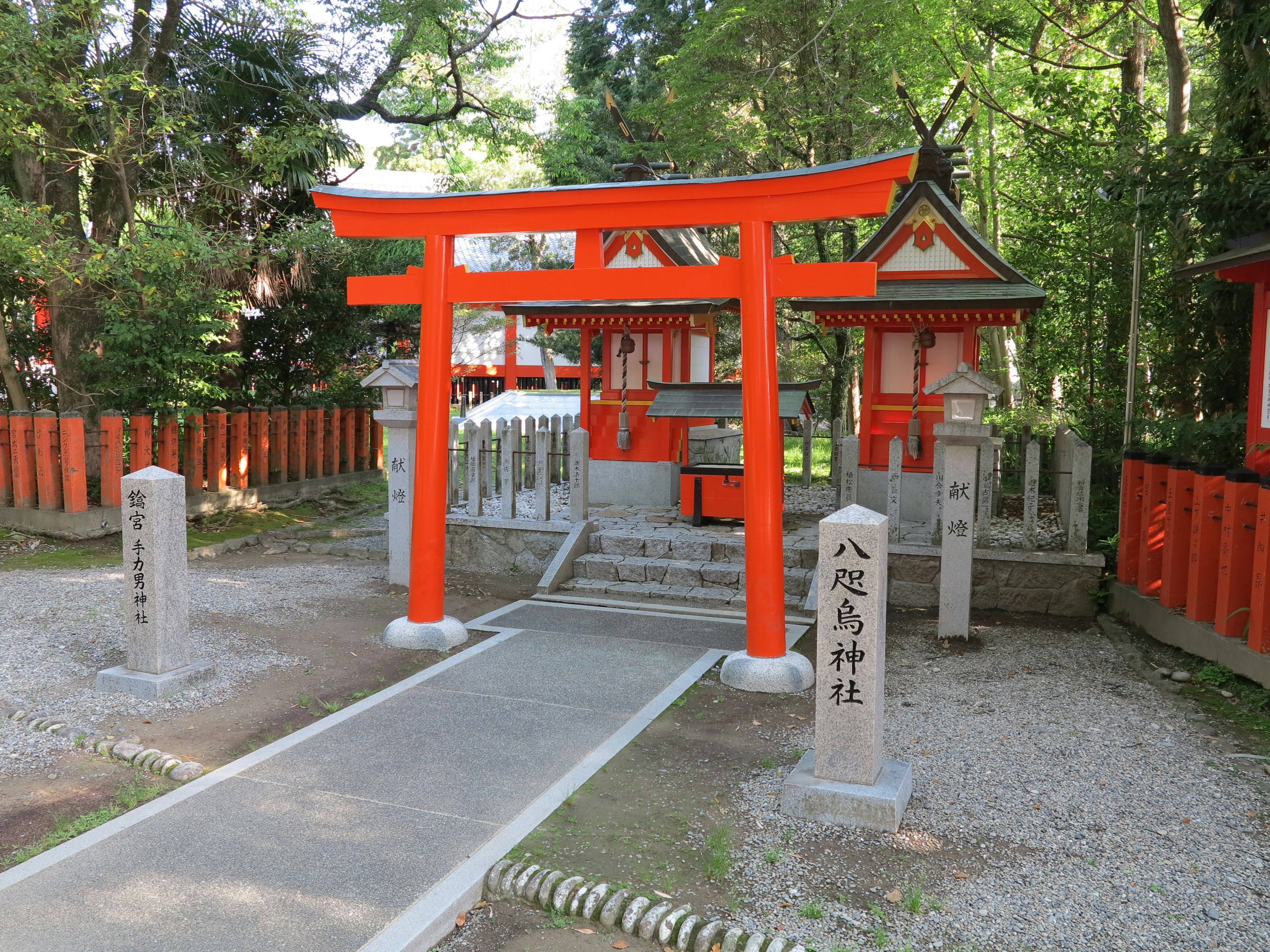 A scenic view of a red torii gate surrounded by green trees and a shrine