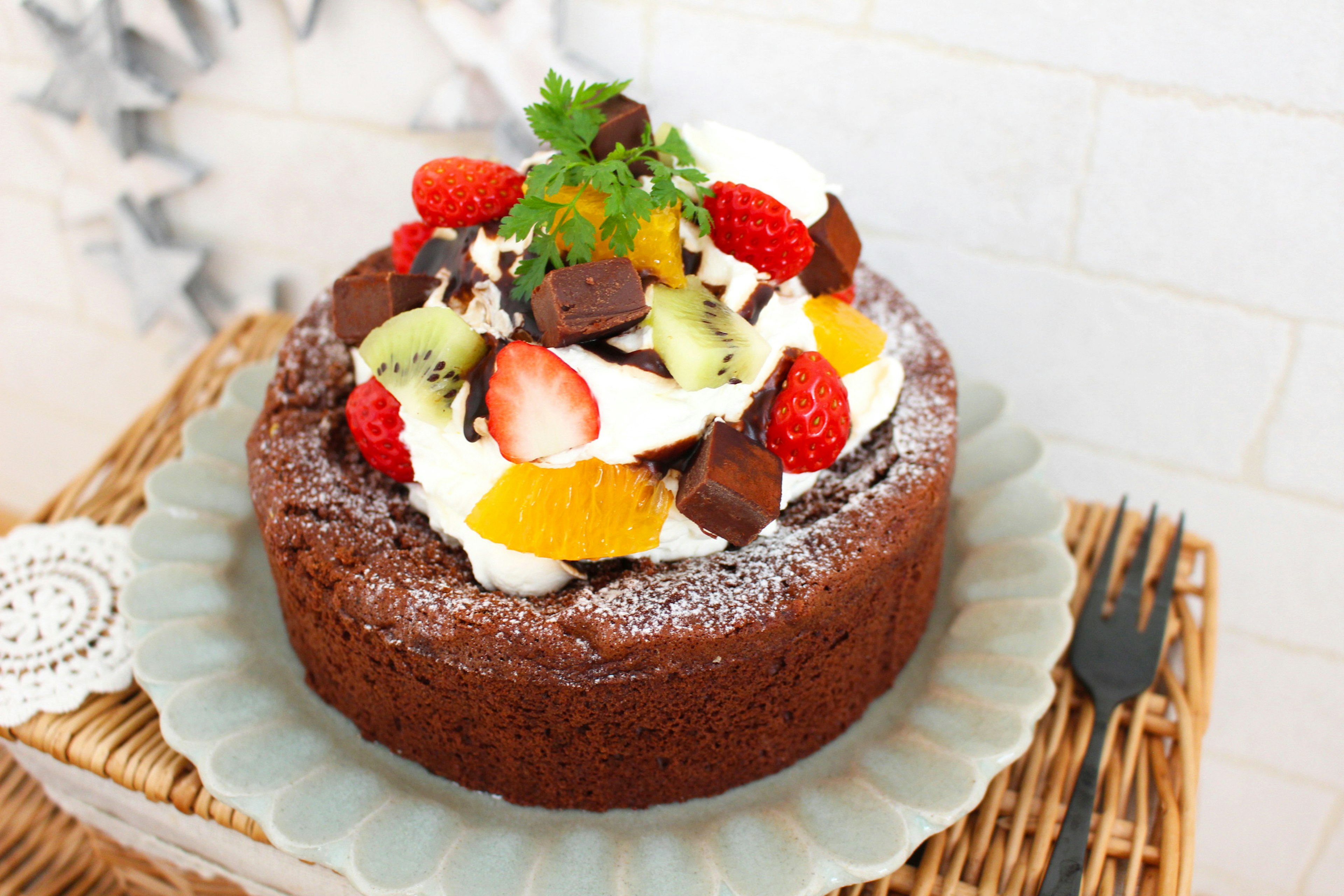 Chocolate cake topped with fruits and cream