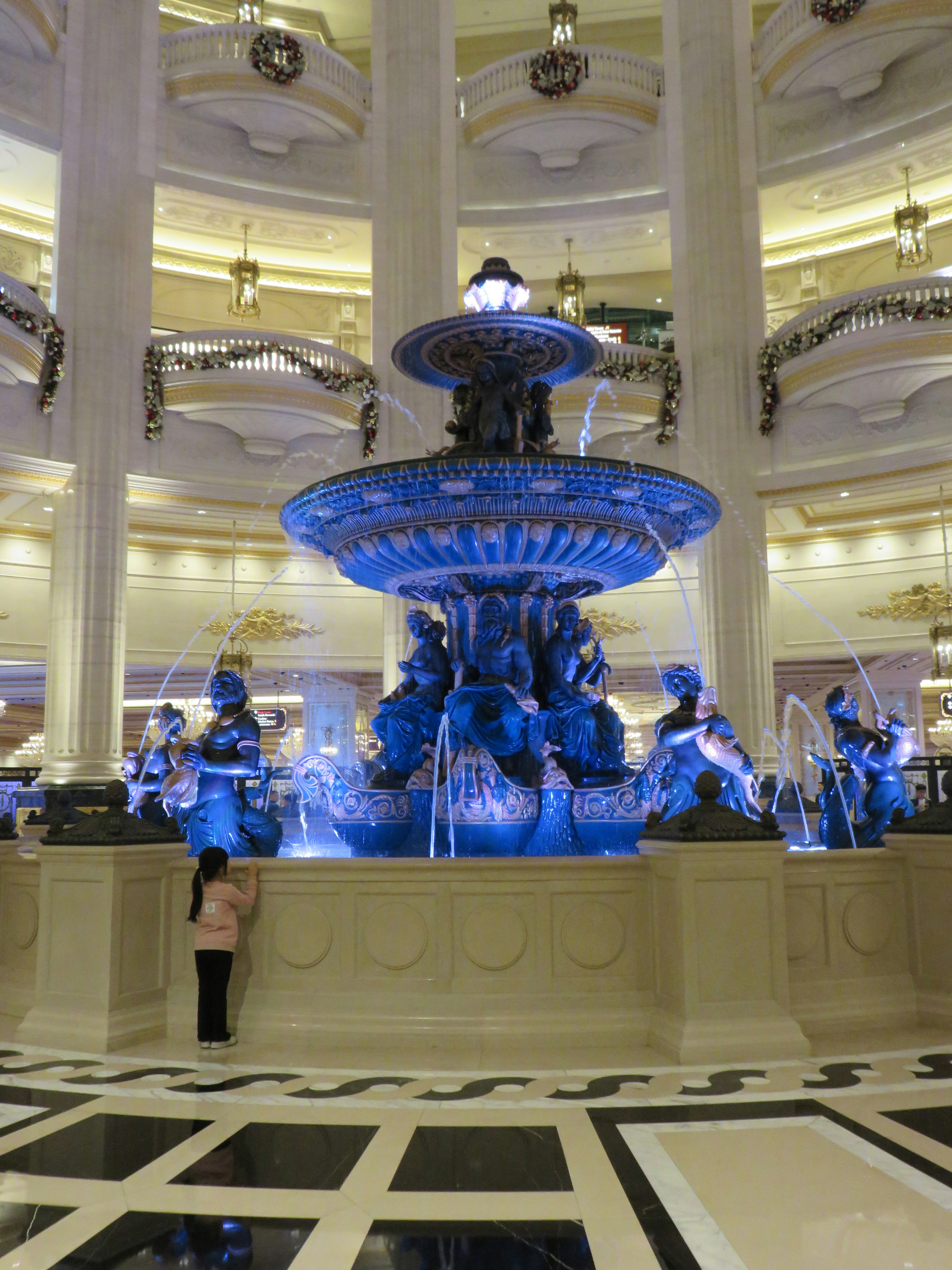 A luxurious fountain illuminated by blue lights in a beautiful indoor setting