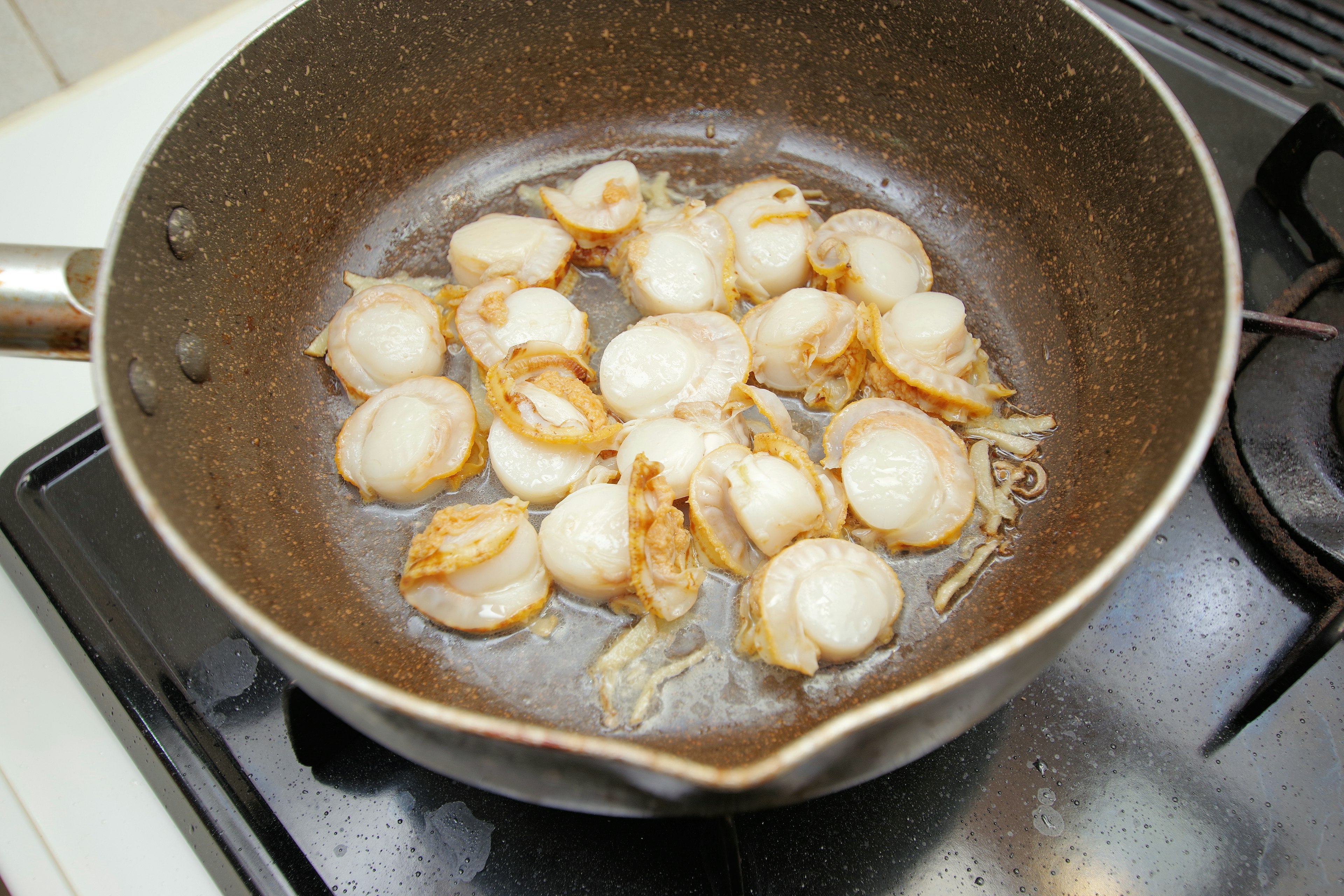 Coquilles Saint-Jacques en train de cuire dans une poêle