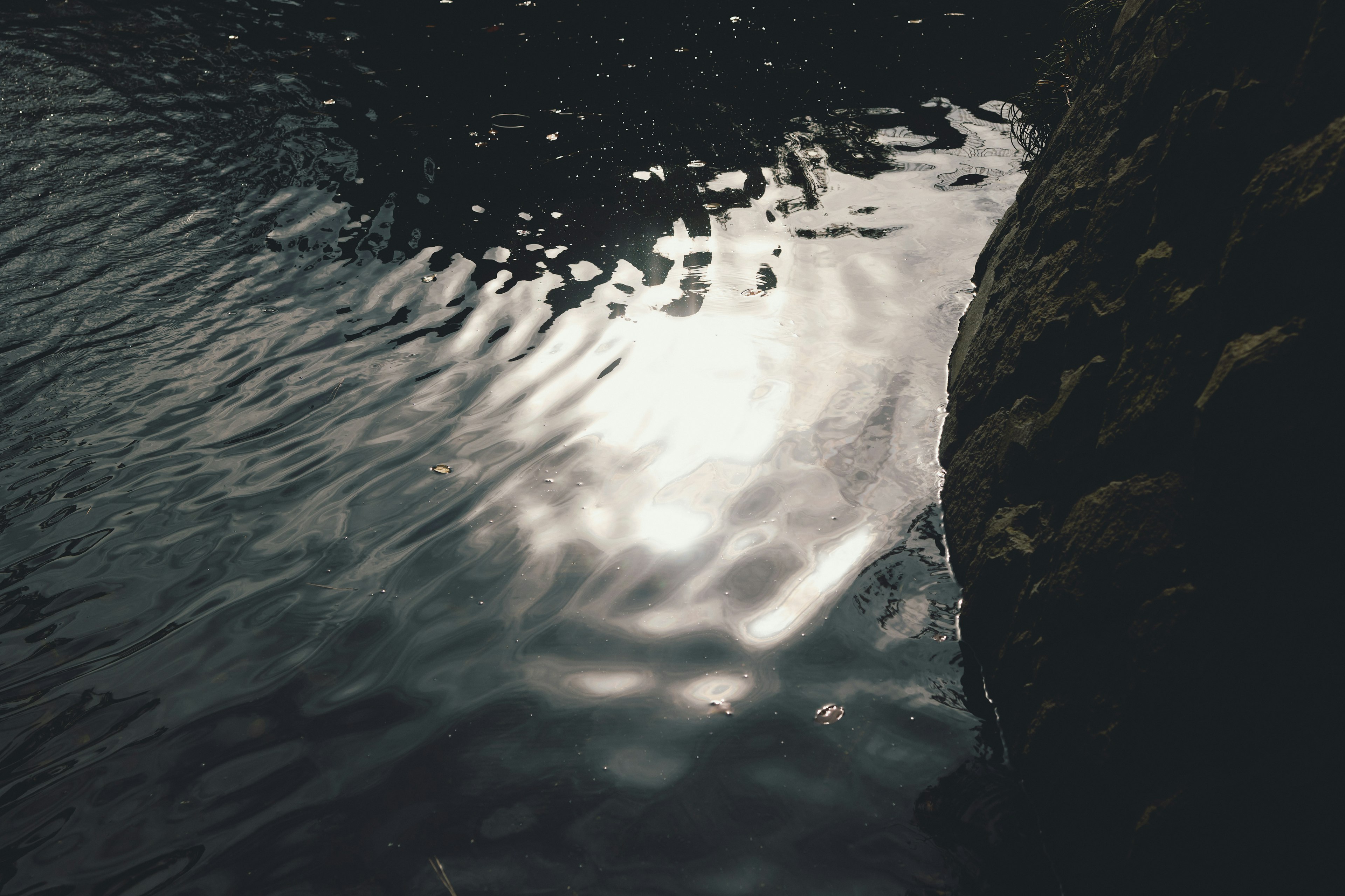 Reflection of light on water surface with rock