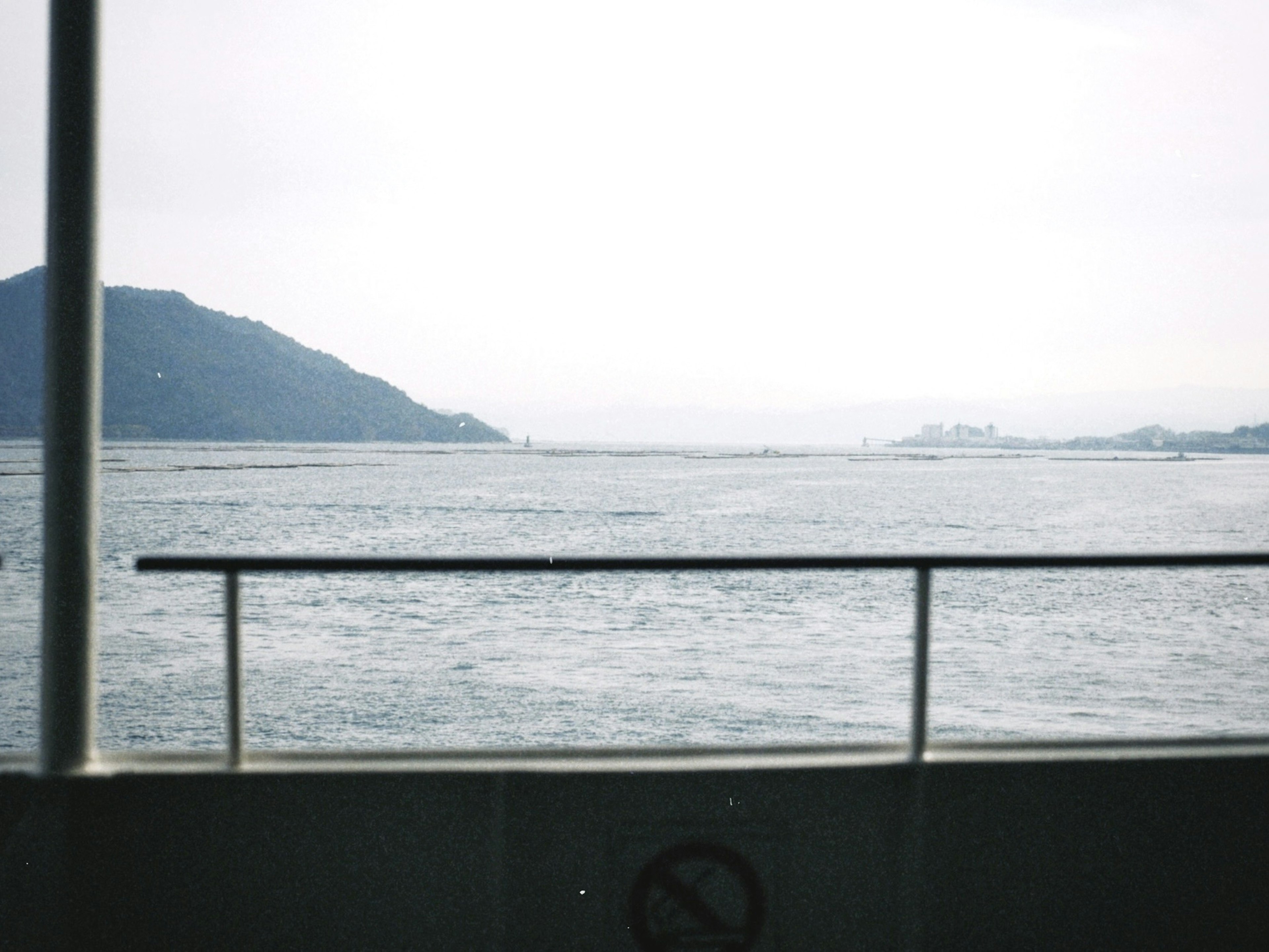 View from a ferry deck showing sea and mountains