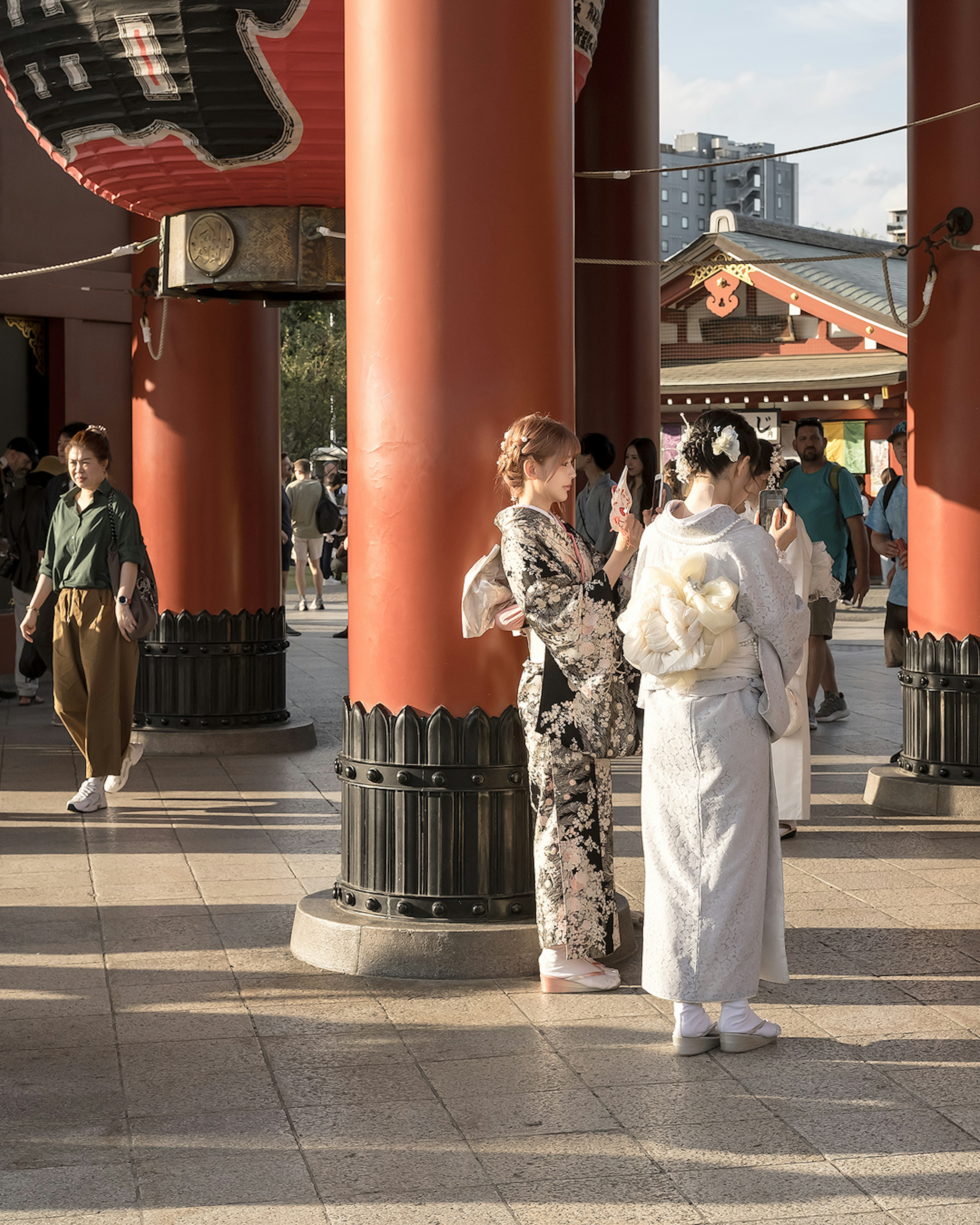 Two women in kimono talking in front of Senso-ji Temple