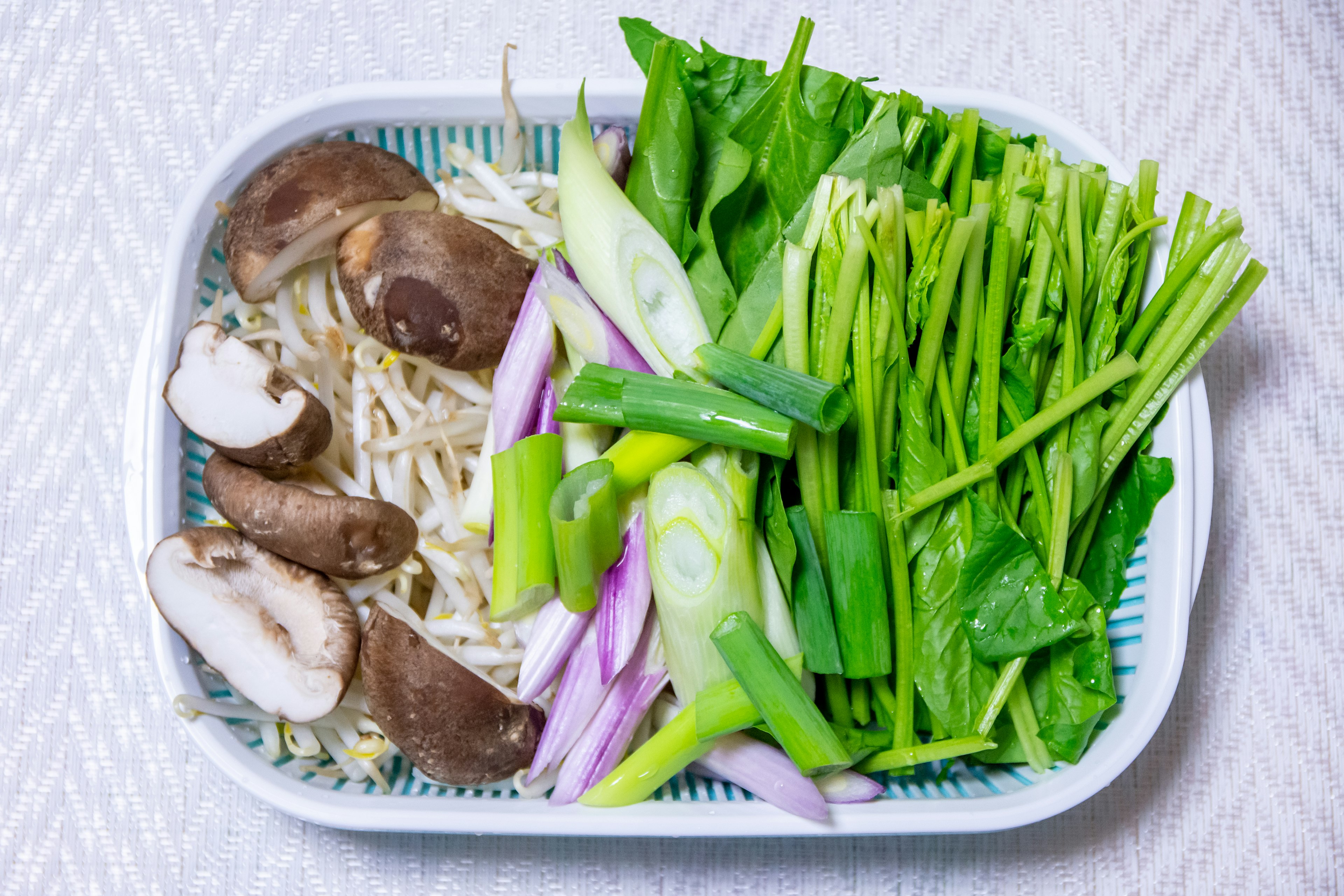 A plate of fresh vegetables and mushrooms arranged beautifully