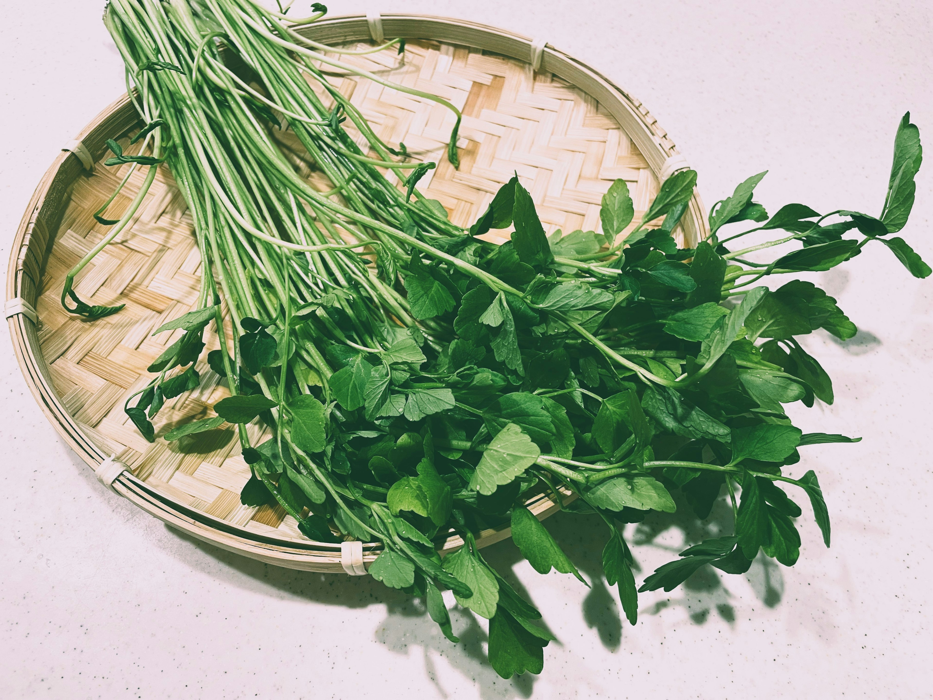 Fresh herbs arranged in a bamboo basket