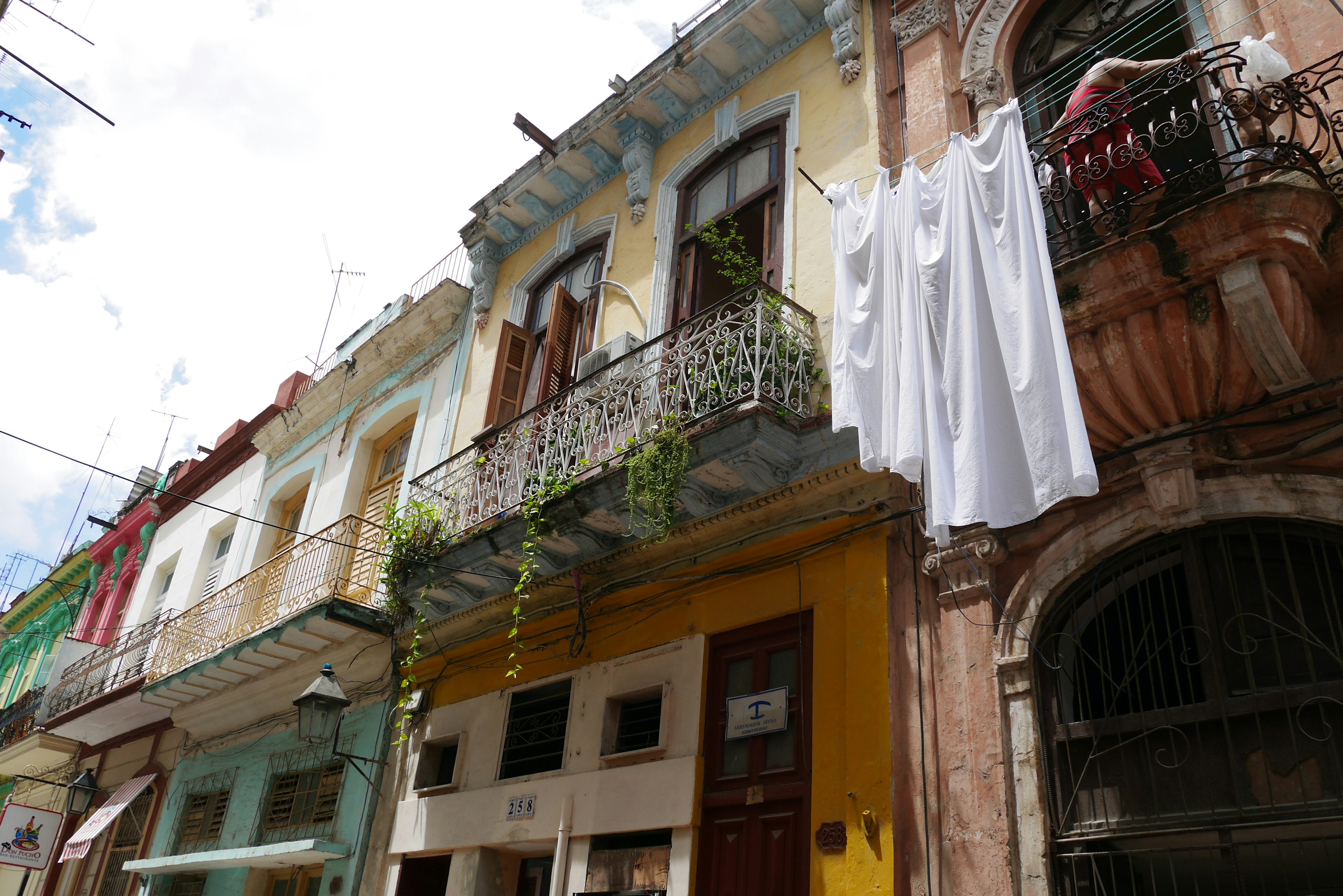 Fachadas de edificios coloridos con una tela blanca colgando de un balcón