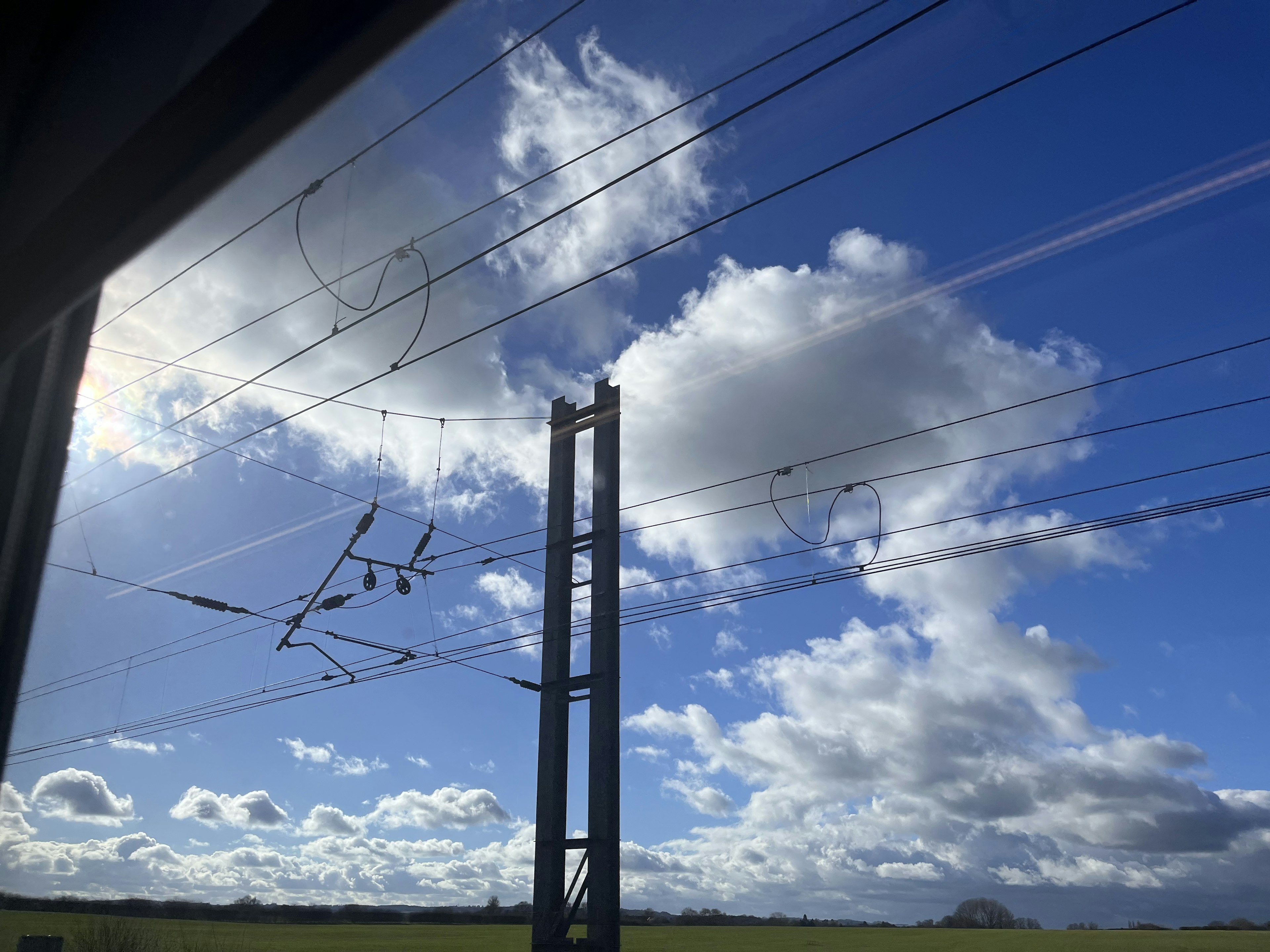 Paysage avec ciel bleu nuages blancs et lignes électriques ferroviaires