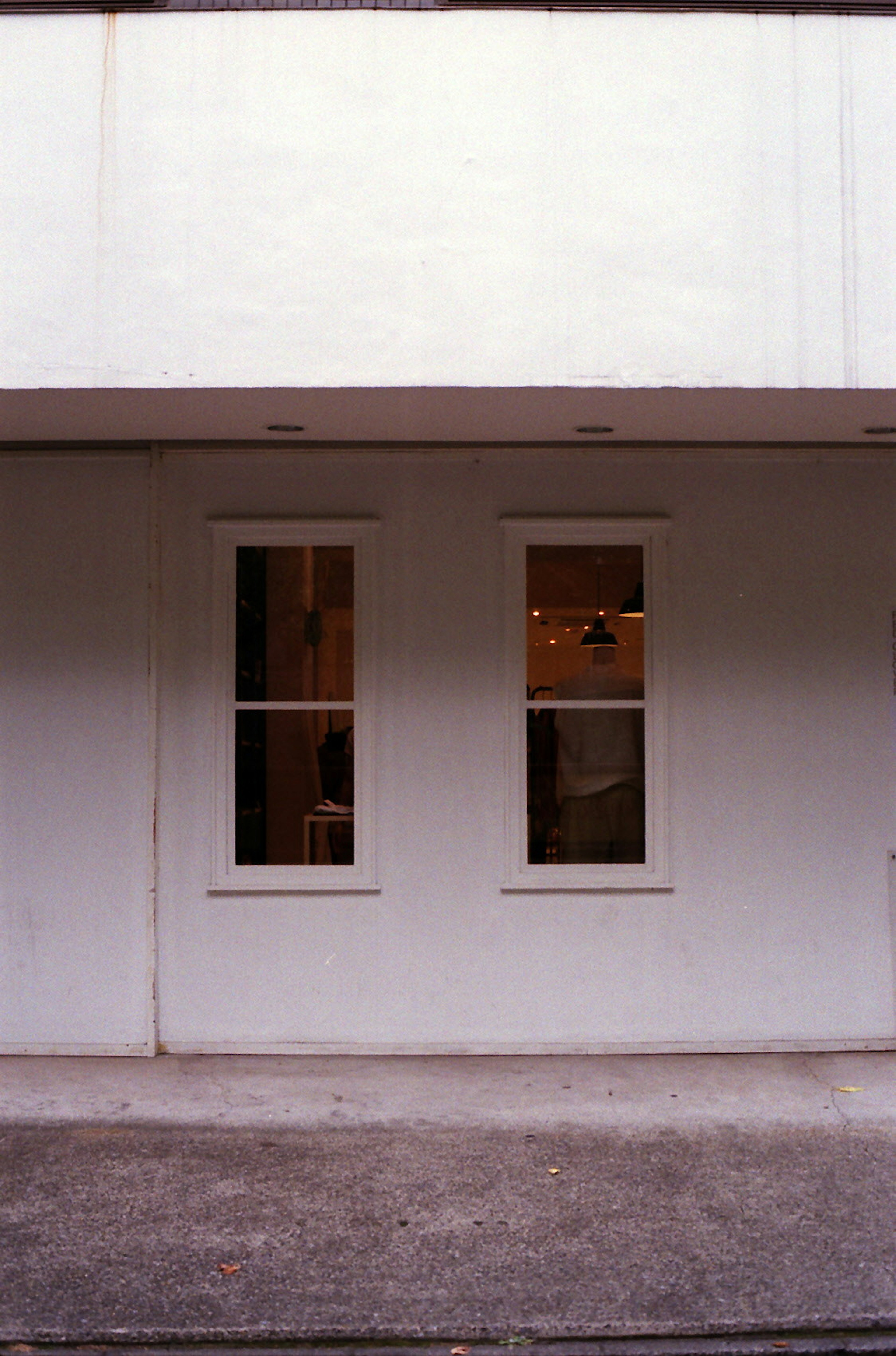 Exterior of a building with two windows on a white wall