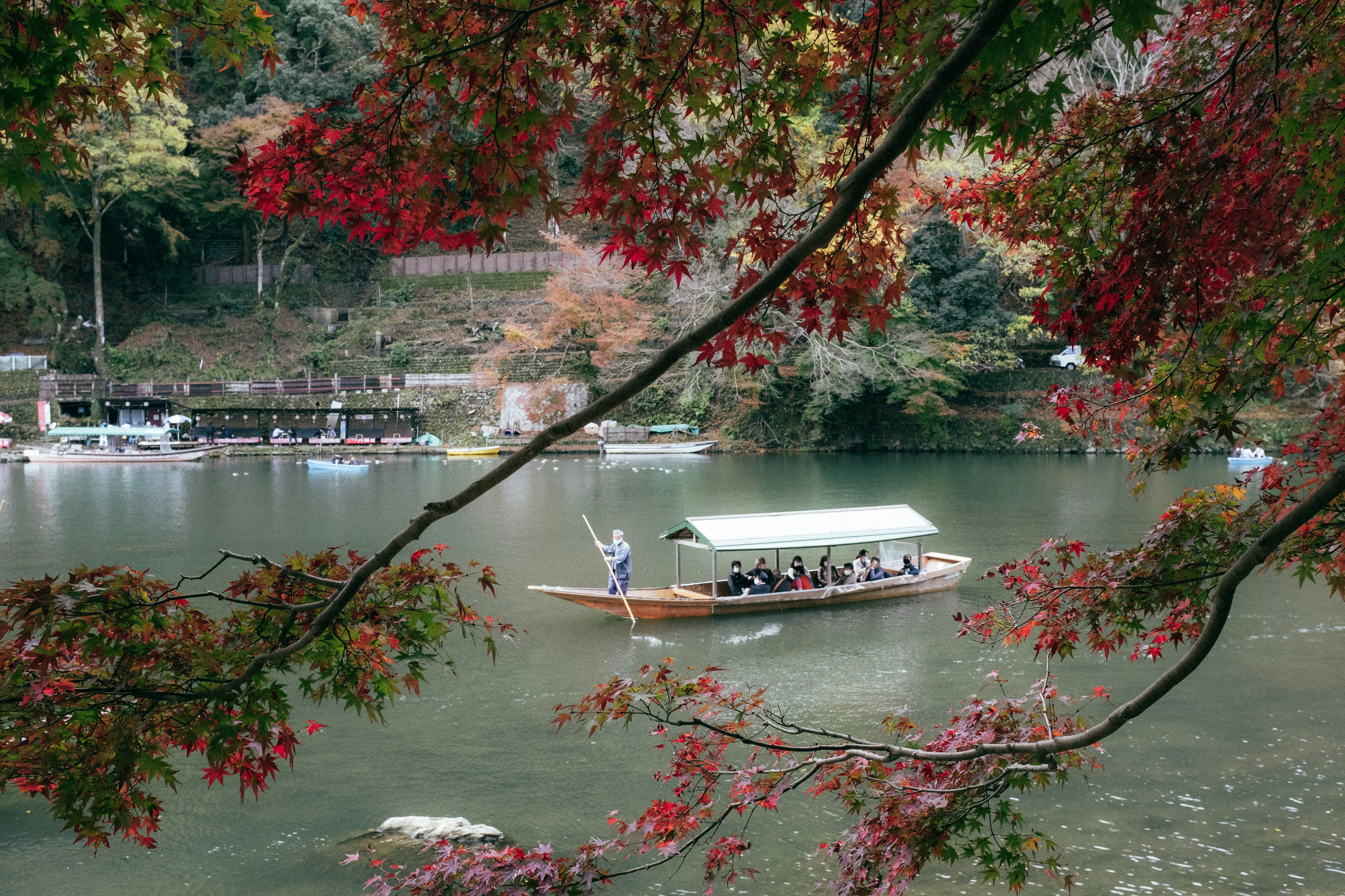 Ein Boot, das durch einen Fluss mit herbstlichen Blättern fährt