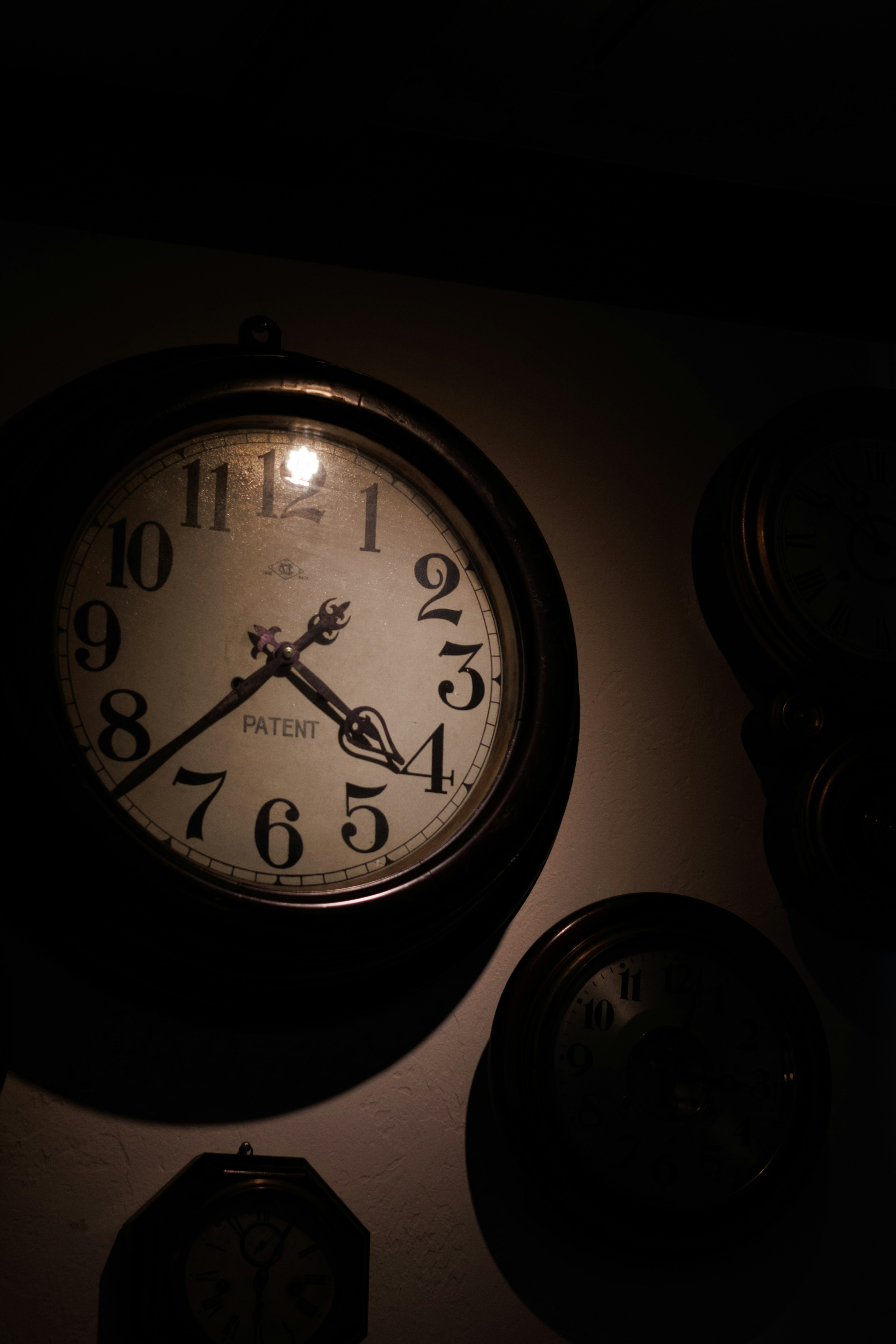 Reloj de pared vintage iluminado contra un fondo oscuro