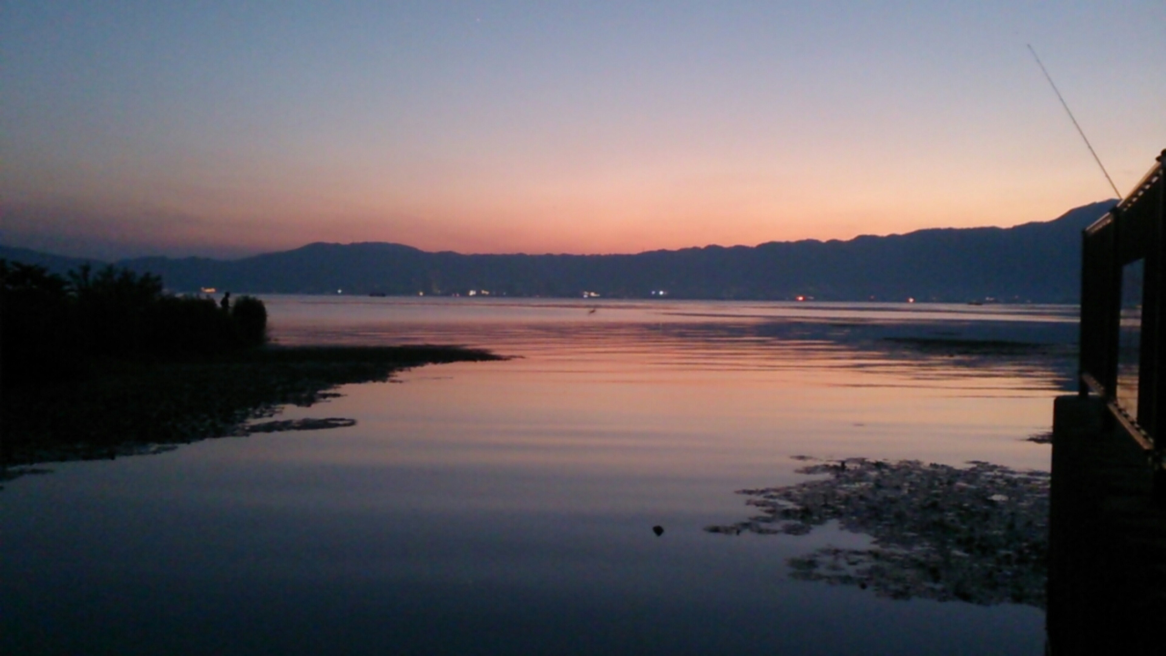 Hermoso atardecer sobre un lago con reflejos en el agua y una atmósfera serena