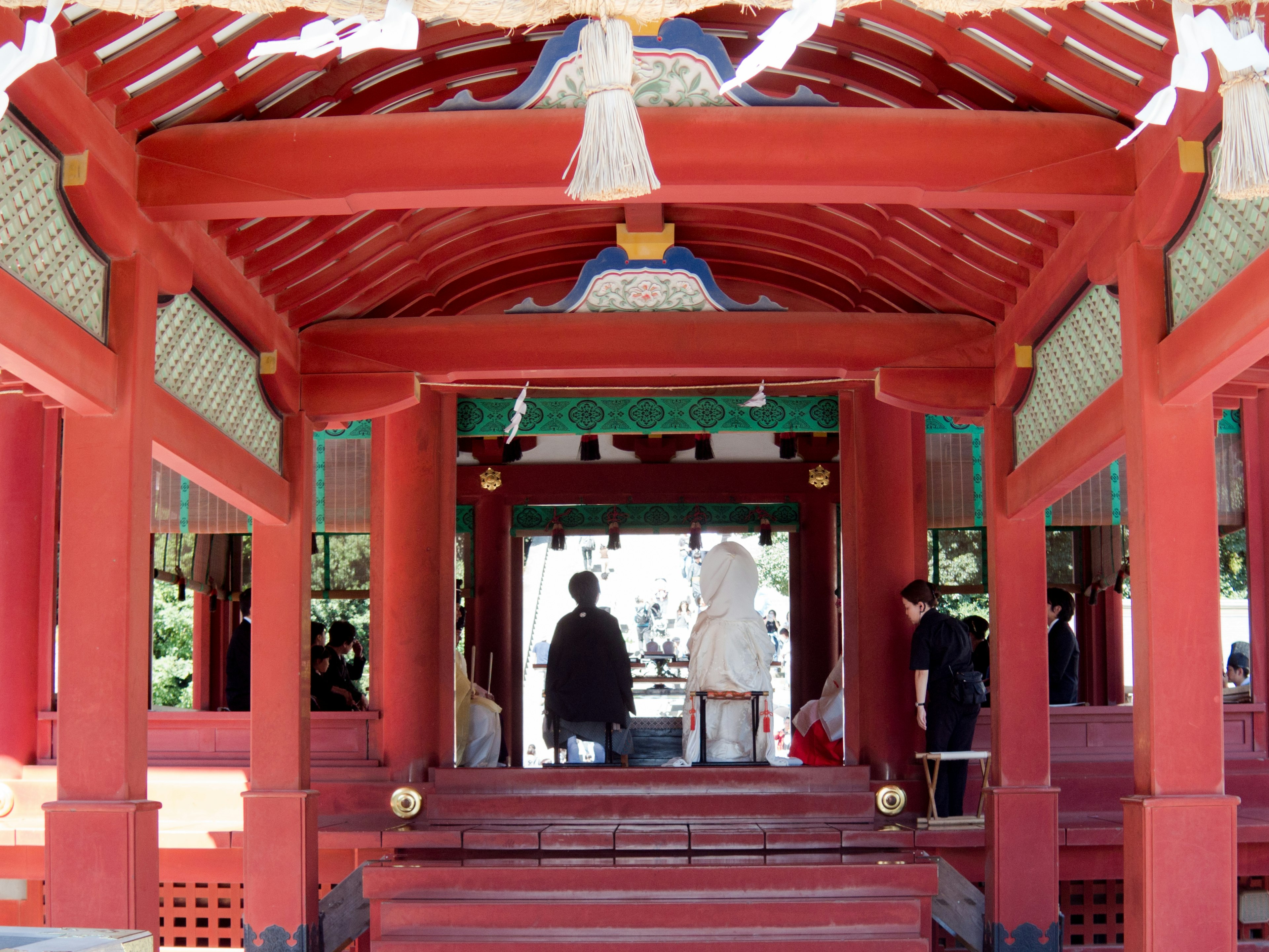 赤い屋根の神社の内部にいる人々の姿