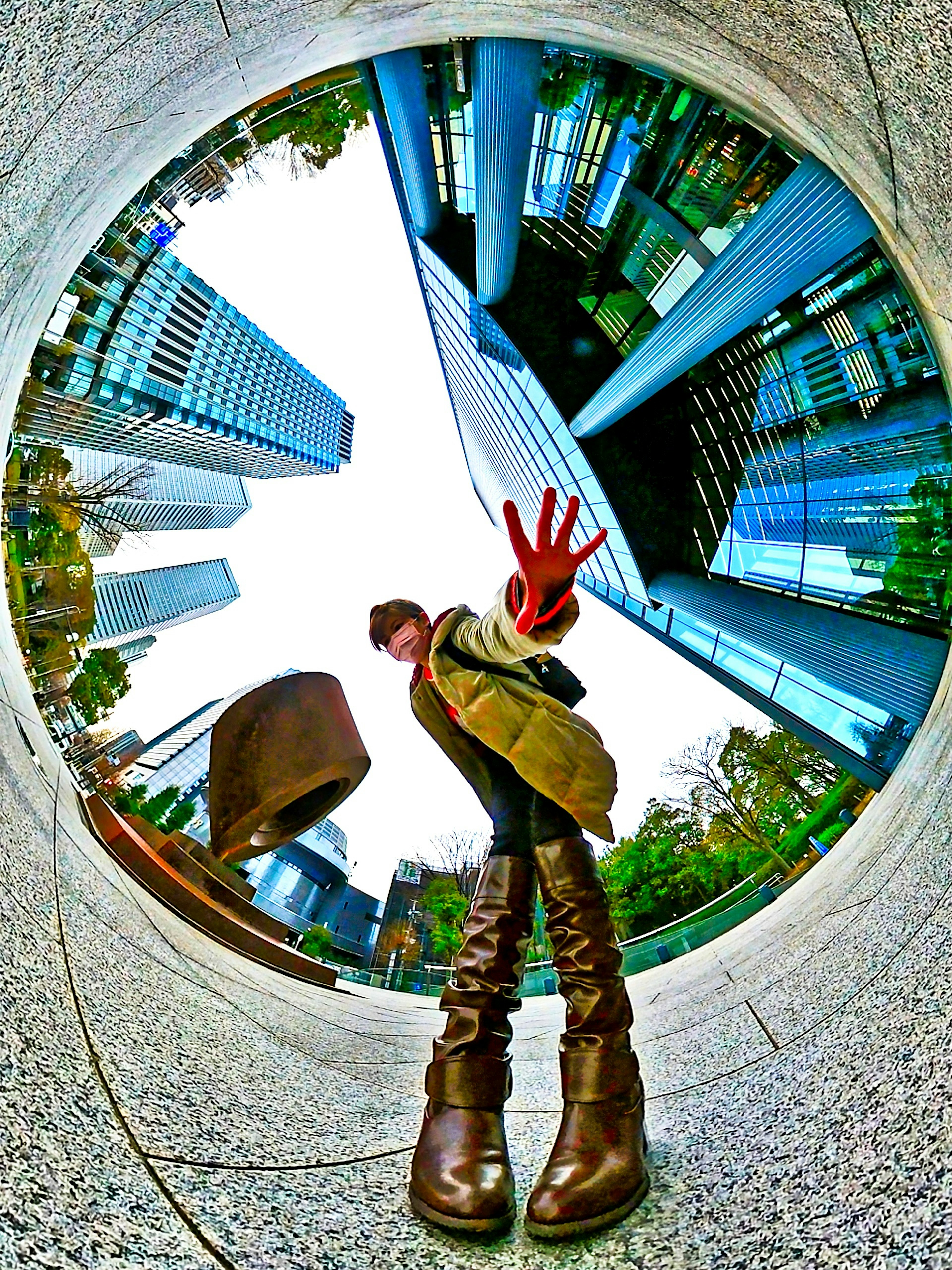 A person with outstretched hand in front of urban skyscrapers from a unique perspective