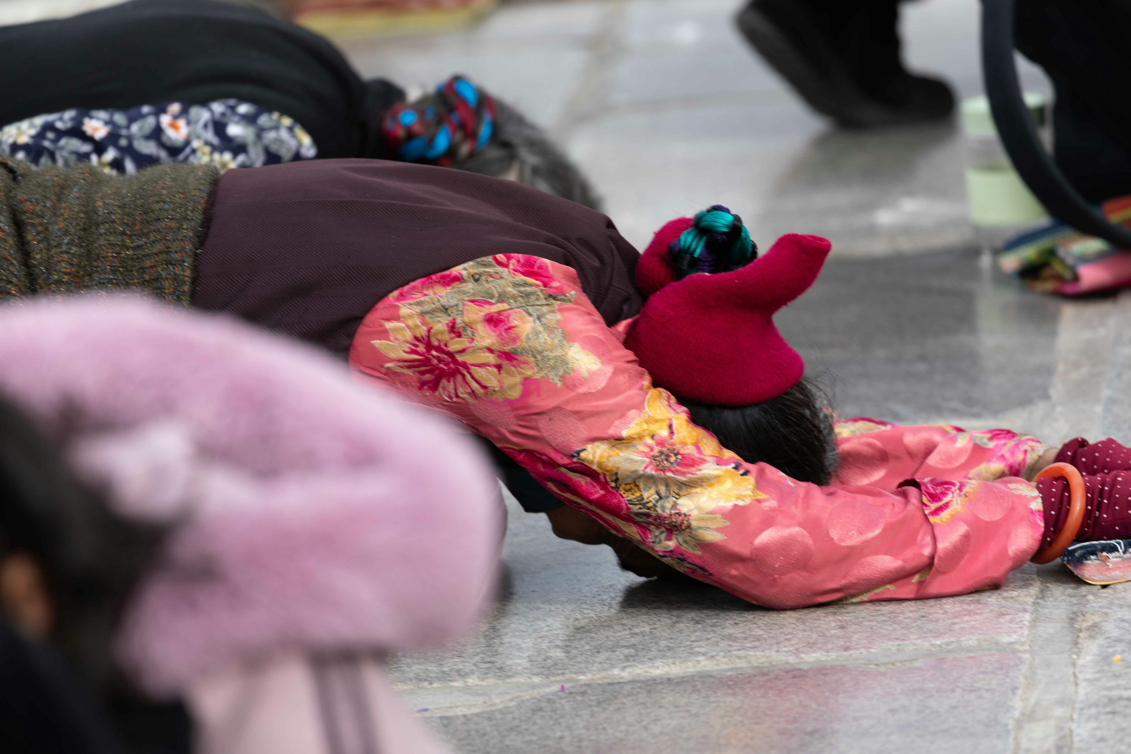 Woman wearing colorful clothing kneeling on the ground